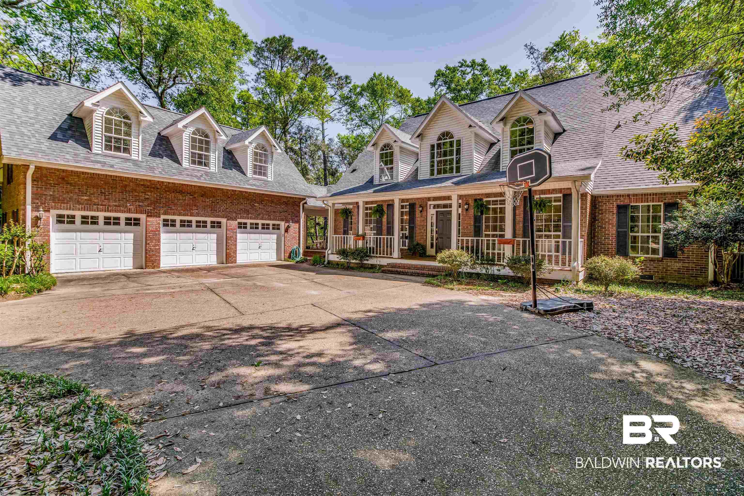 Image 4: Brick and siding exterior featuring a three-car garage with white panel doors