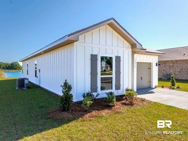 Image 2: White board and batten siding exterior featuring a grey shingle roof and grey window shutters