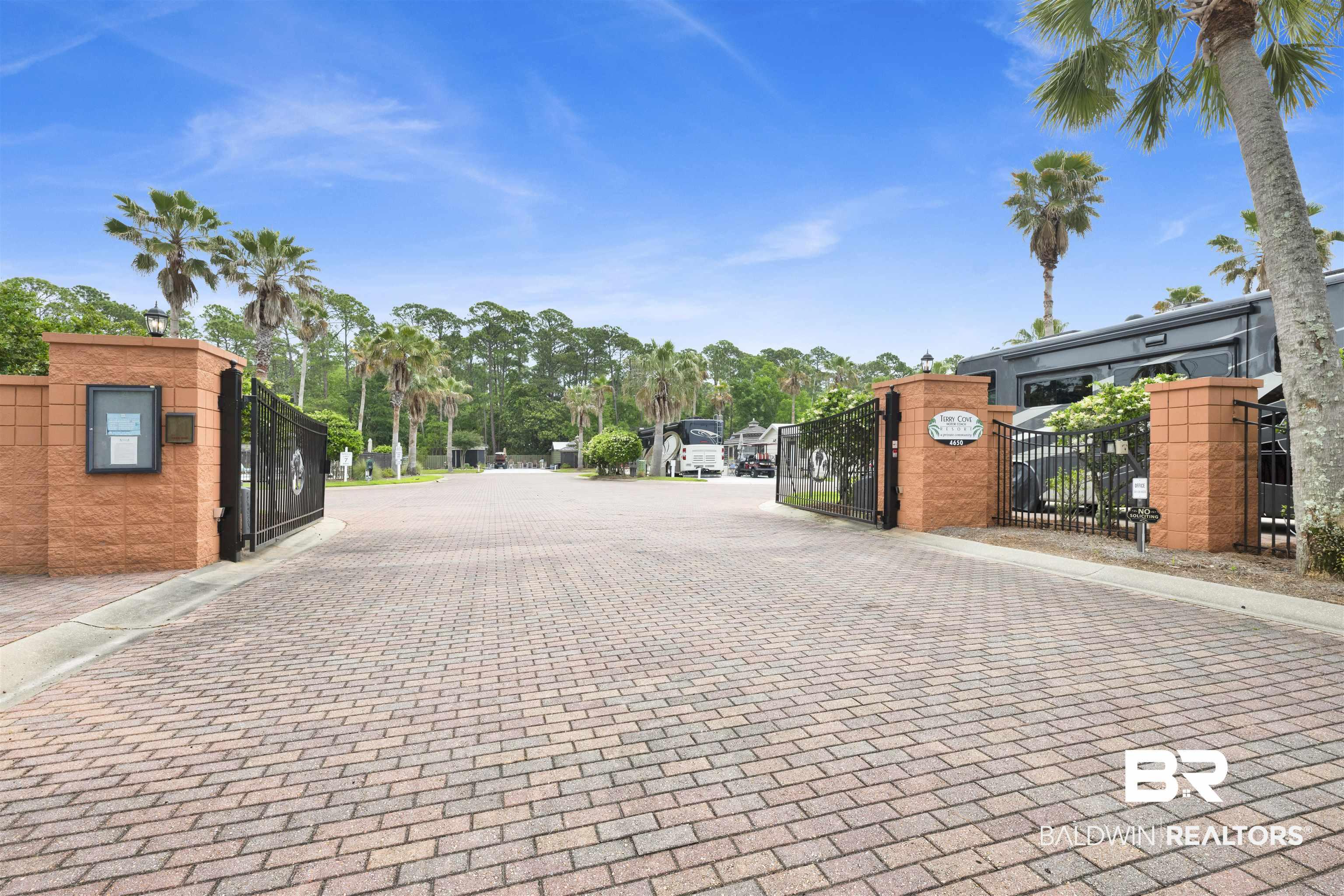Image 2: Gated community entrance featuring brick pillars and wrought iron gates