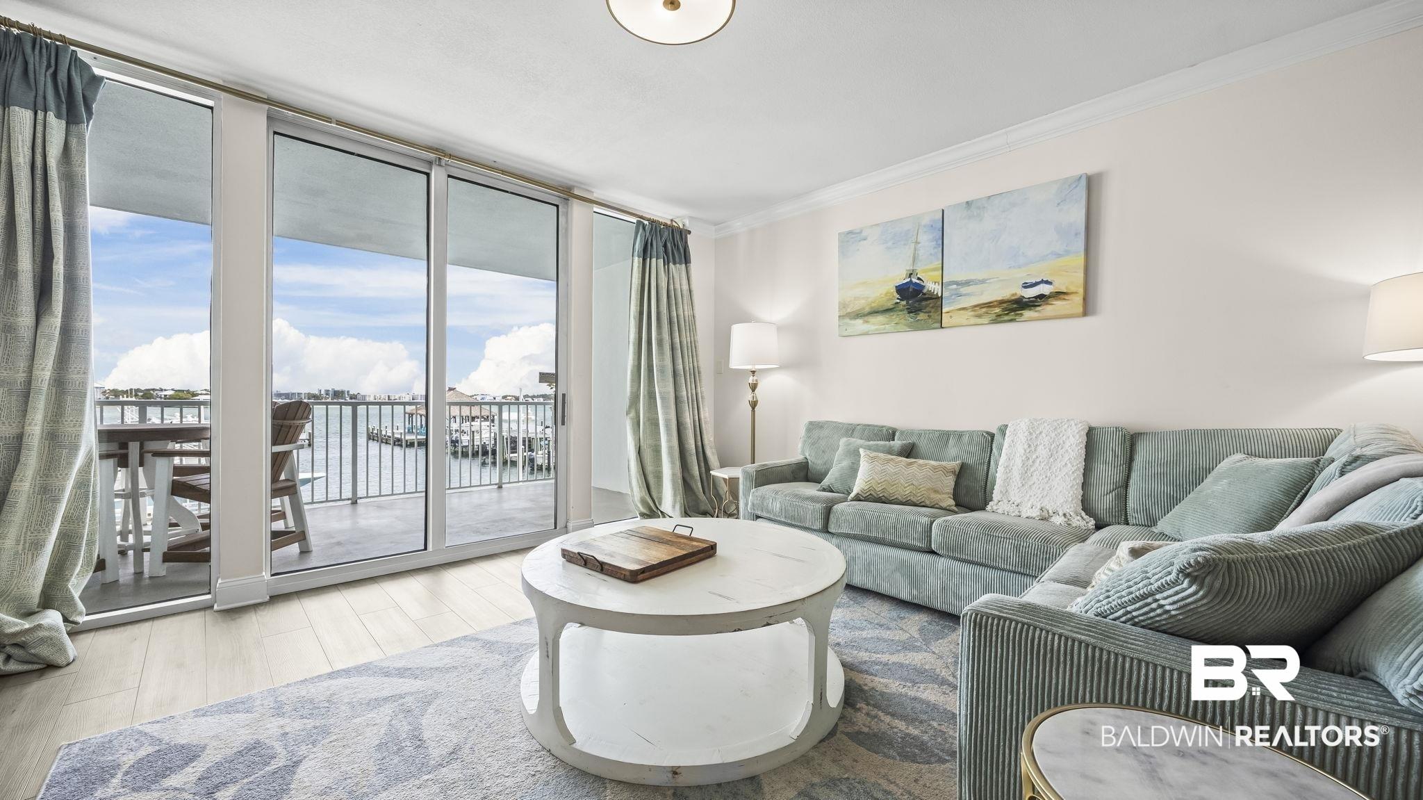 Image 3: Living room featuring floor to ceiling windows, ornamental molding, and wood finished floors