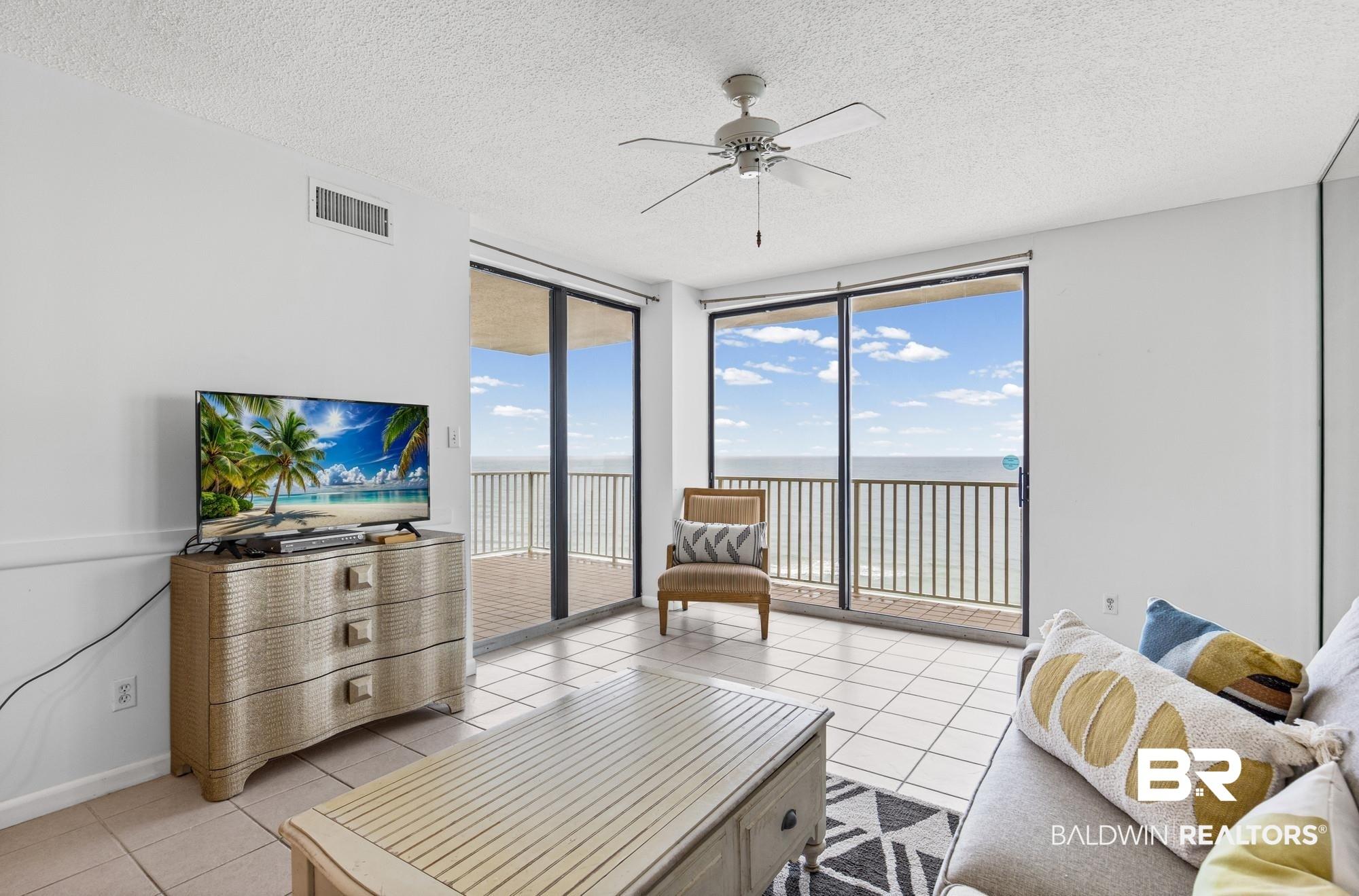 Image 3: Floor-to-ceiling sliding glass doors open to a balcony with metal railings and ocean views
