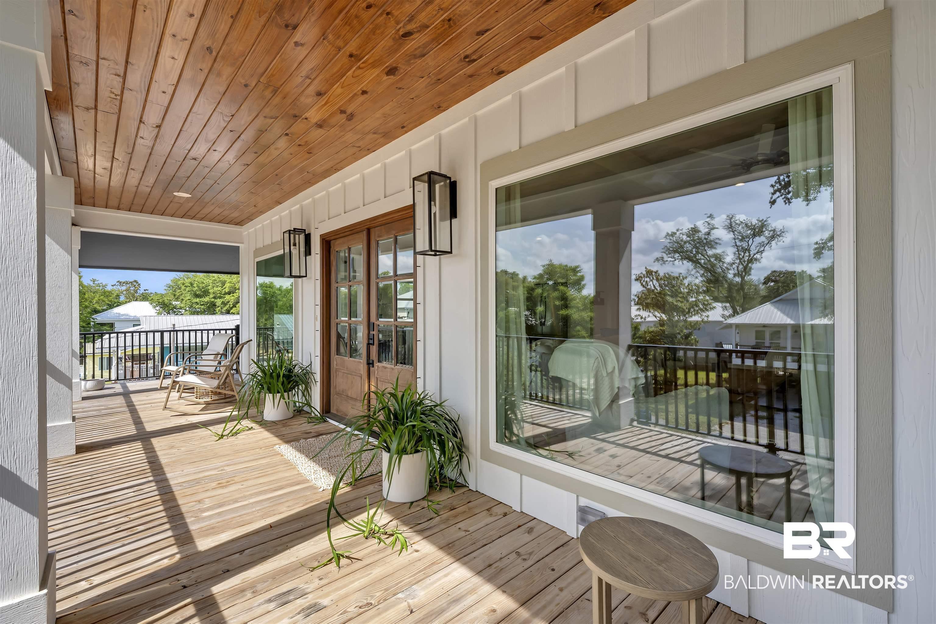 Image 2: Expansive front porch featuring wood-finish flooring and a natural wood plank ceiling