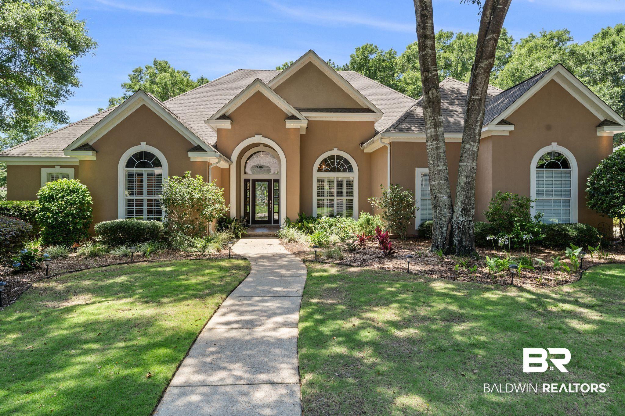 Image 1: Stucco exterior residence with arched entry and transom window