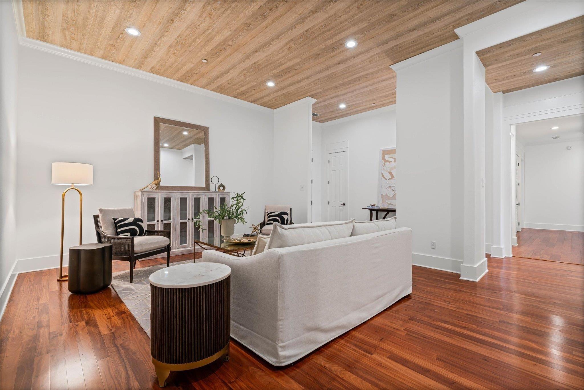 Image 4: Living area with dark wood-style flooring, recessed lighting, and wood ceiling