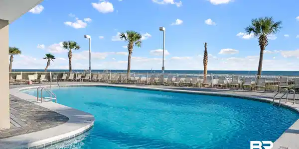 Image 2: Community pool featuring a patio area and a water view