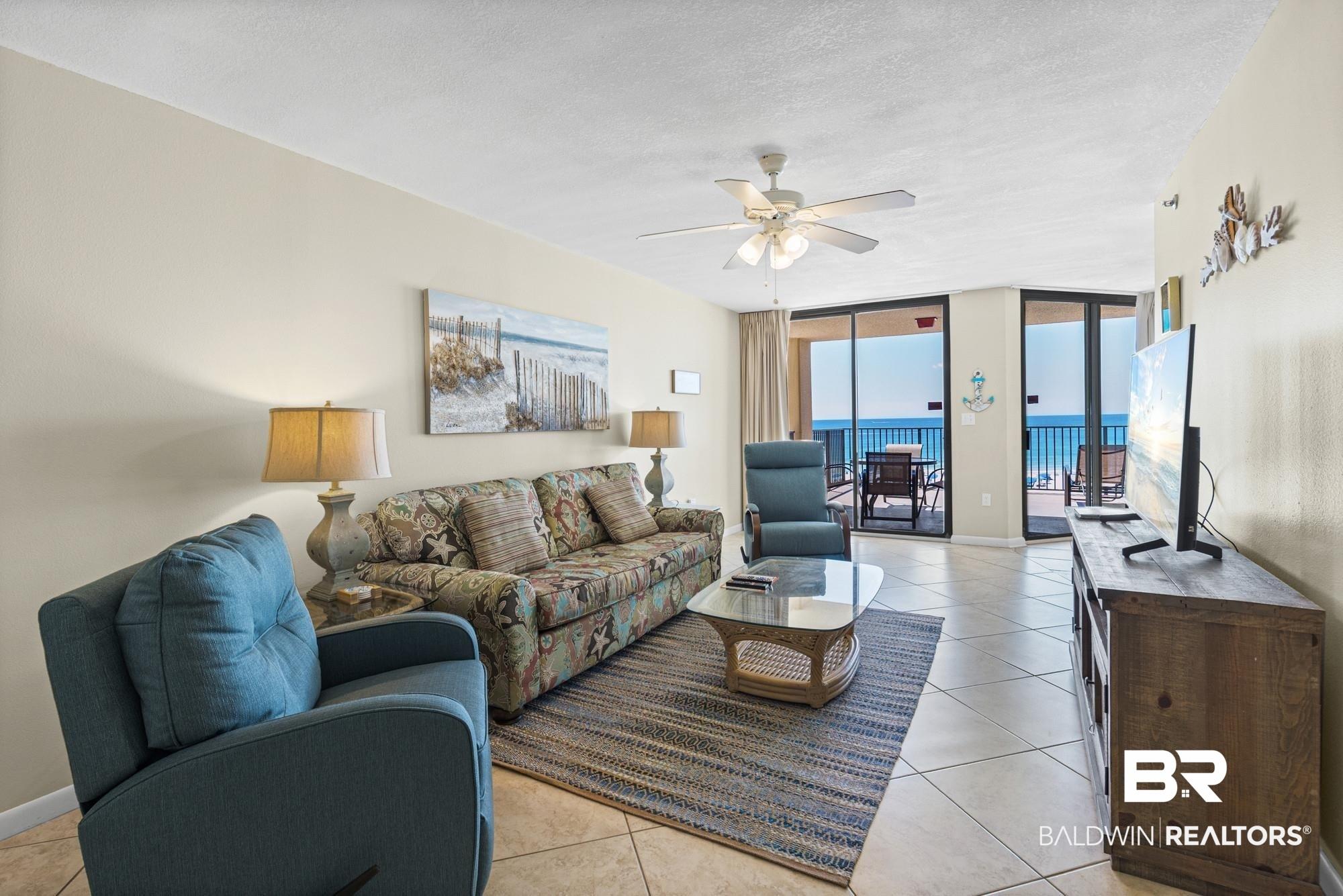 Image 3: Living area featuring ceramic tile flooring, a ceiling fan with integrated lighting, and direct access to an exterior balcony through sliding glass doors