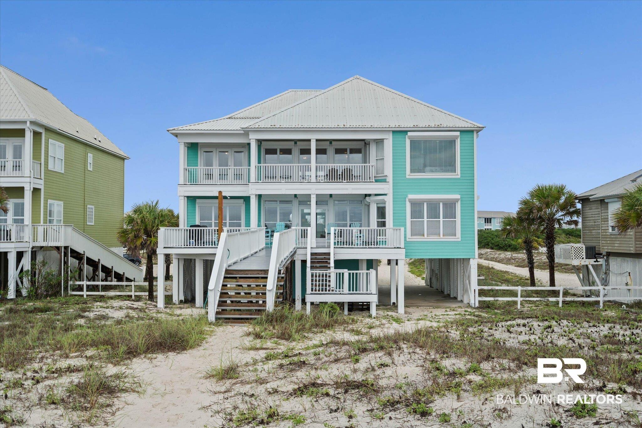 Image 4: Three-story coastal residence featuring a turquoise exterior and multiple private balconies