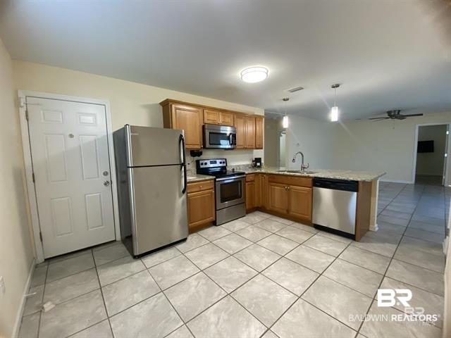 Image 3: Kitchen featuring stainless steel appliances, light tile patterned floors, a peninsula, light countertops, and ceiling fan
