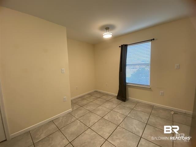 Image 4: Spare room with light tile patterned floors and baseboards