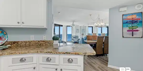 Image 4: Kitchen featuring white cabinetry, a peninsula, light wood-style flooring, light stone countertops, and open floor plan