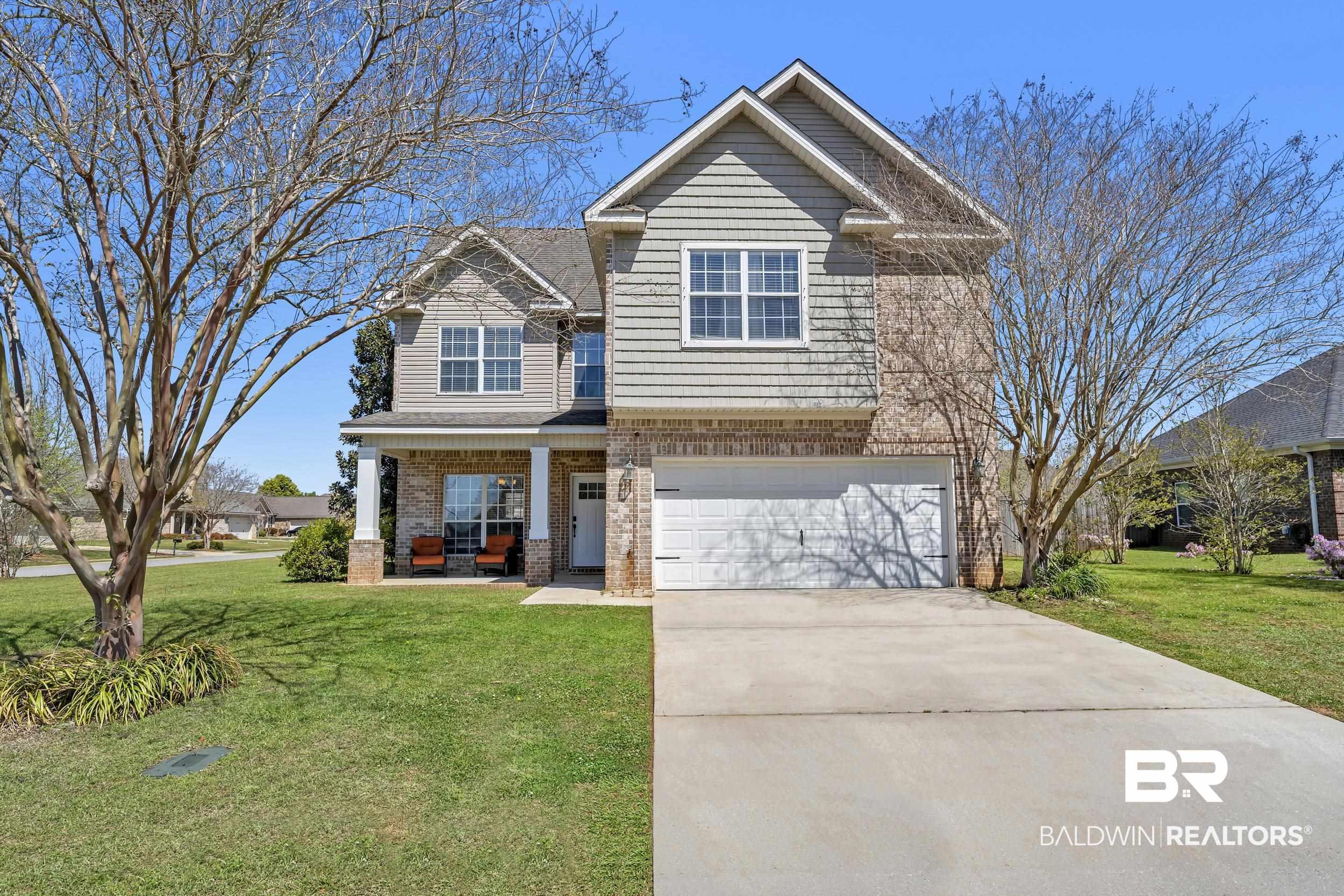 Image 4: Craftsman-style home featuring a front lawn, brick siding, covered porch, a garage, and driveway