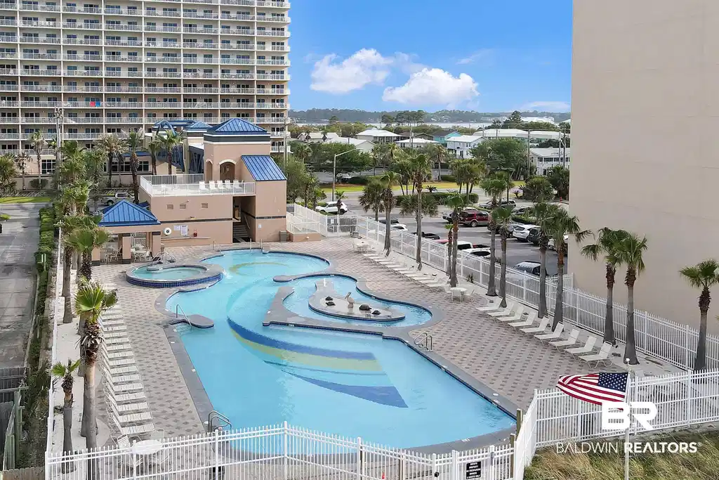 Image 1: Expansive outdoor pool area featuring a large freeform swimming pool with integrated spa