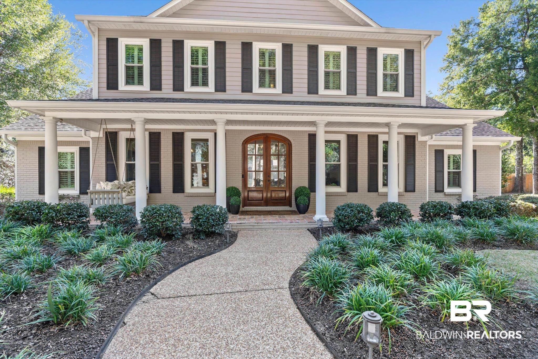 Image 2: View of front of house featuring brick siding, covered porch, and french doors