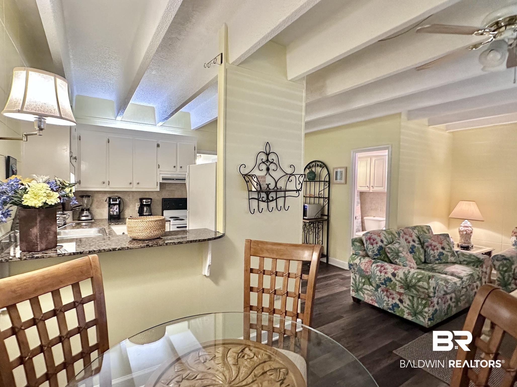 Image 2: Dining space featuring beam ceiling, dark wood-style floors, and a ceiling fan