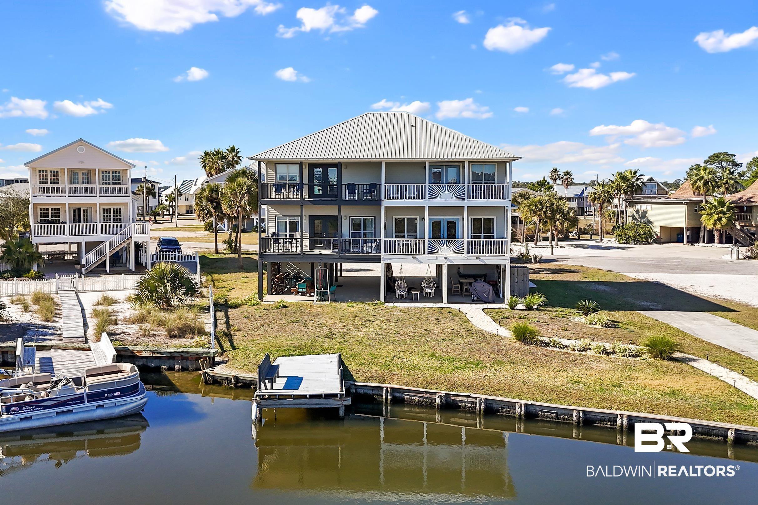 Image 4: Rear view of house featuring a water view, a patio, and a residential view