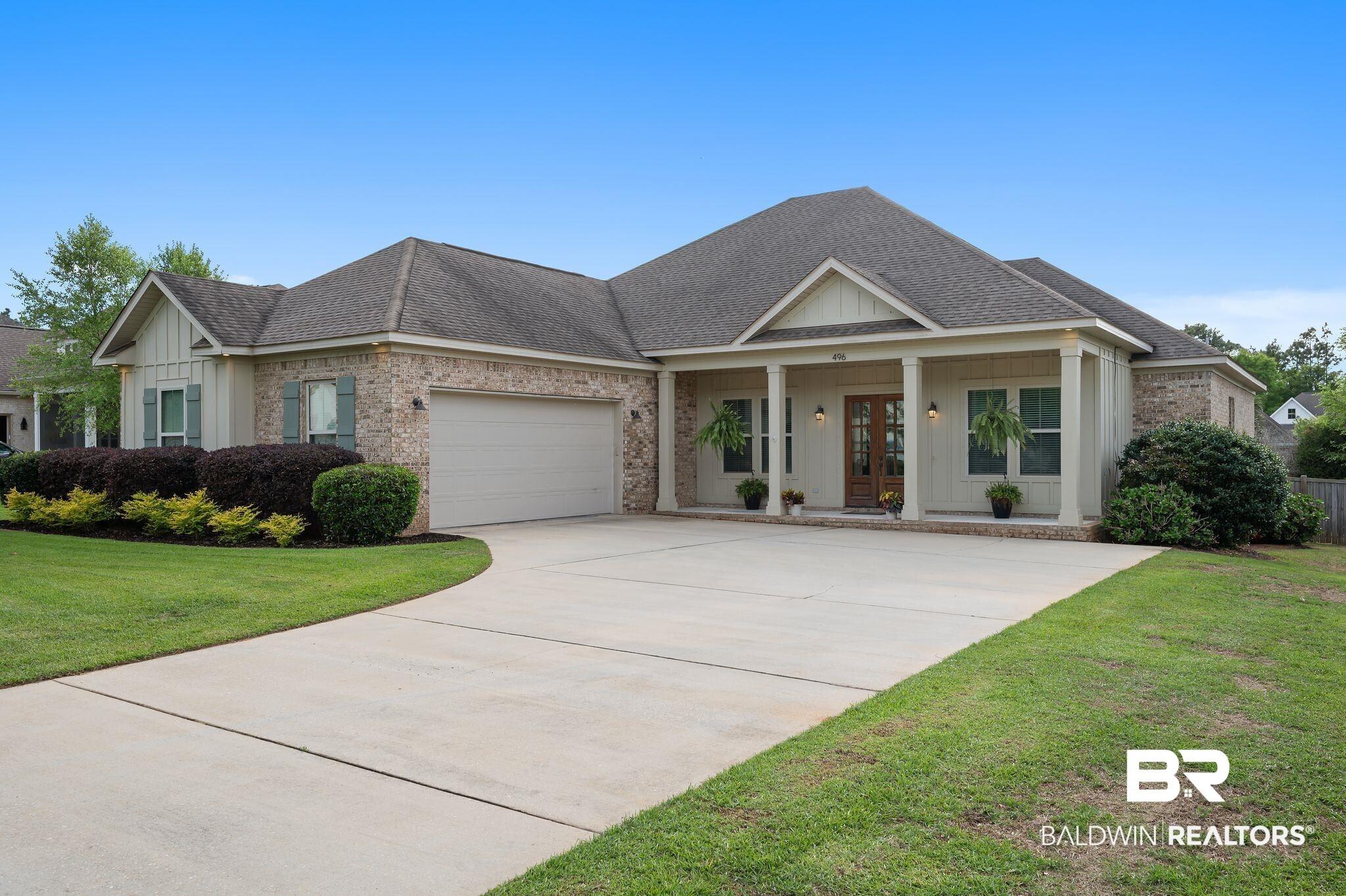 Image 1: View of front of property with a shingled roof, brick siding, covered porch, and an attached garage