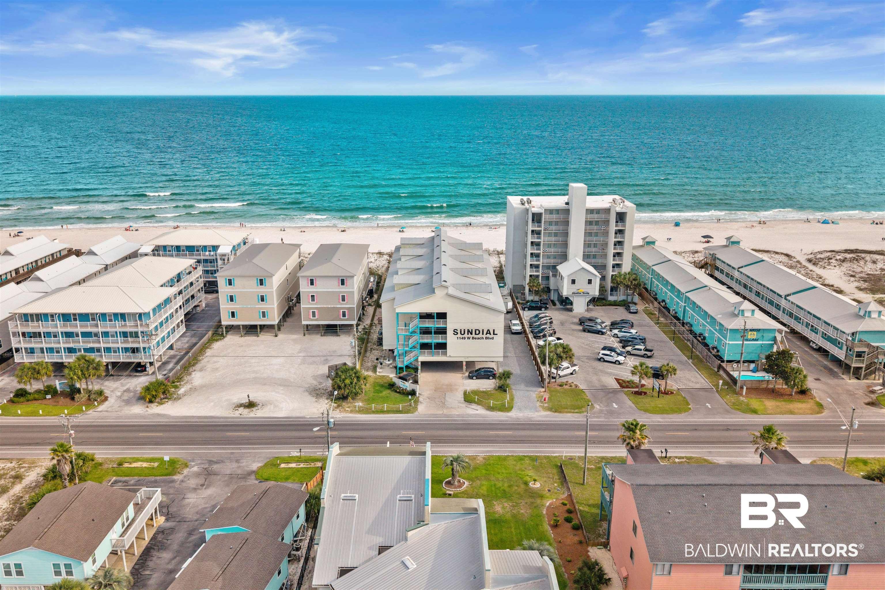 Image 2: Expansive beachfront property featuring a multi-story building with a large parking area