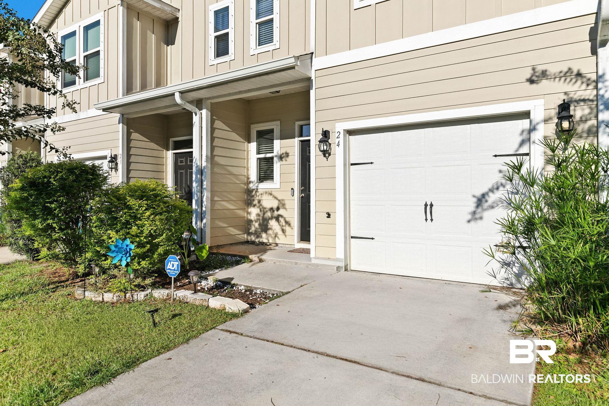 Image 4: Entrance to property featuring board and batten siding, driveway, a porch, and an attached garage