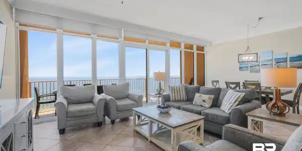 Image 2: Living area with a water view, a wall of windows, light tile patterned floors, crown molding, and a ceiling fan