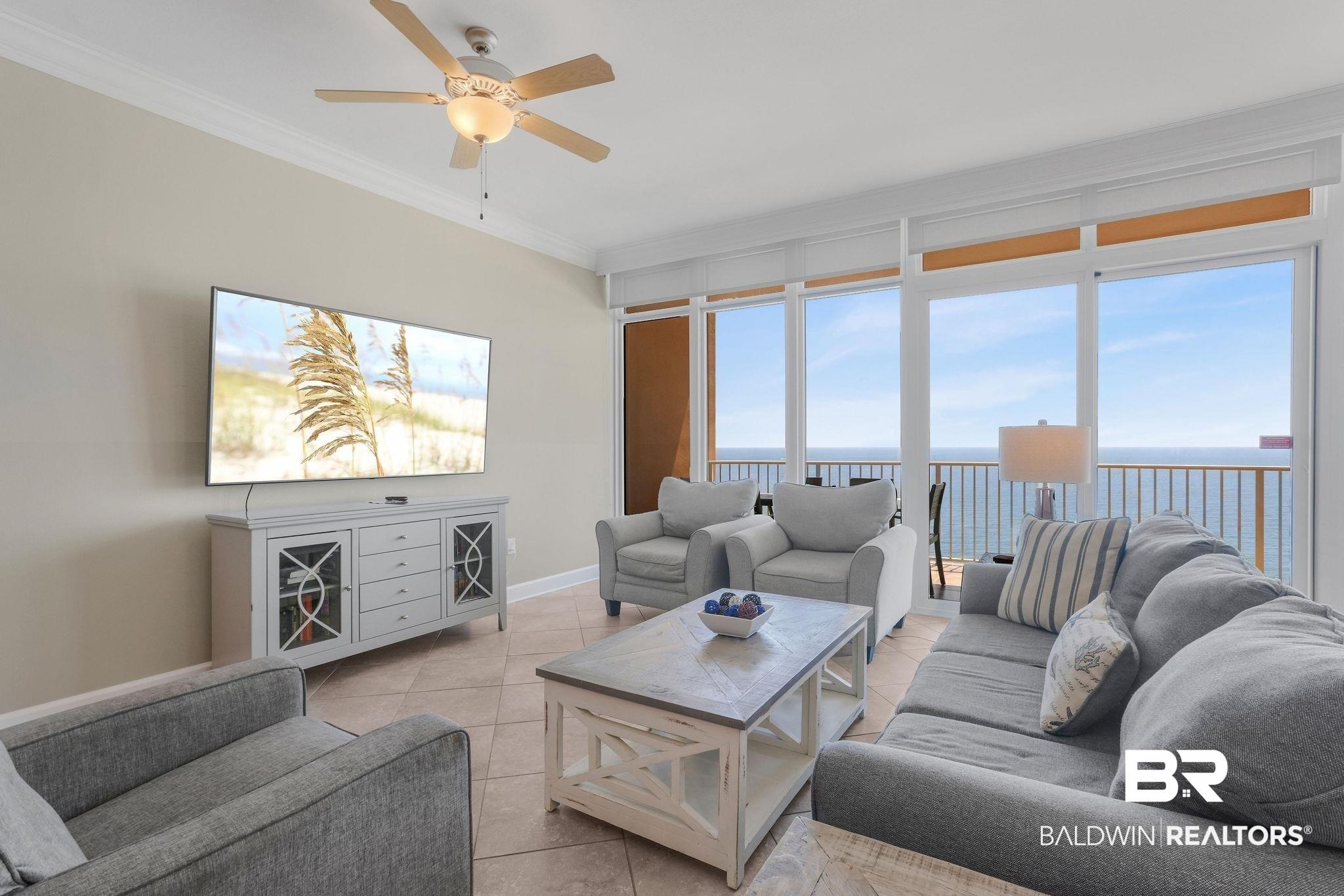 Image 3: Living room with light tile patterned floors, ornamental molding, and a ceiling fan