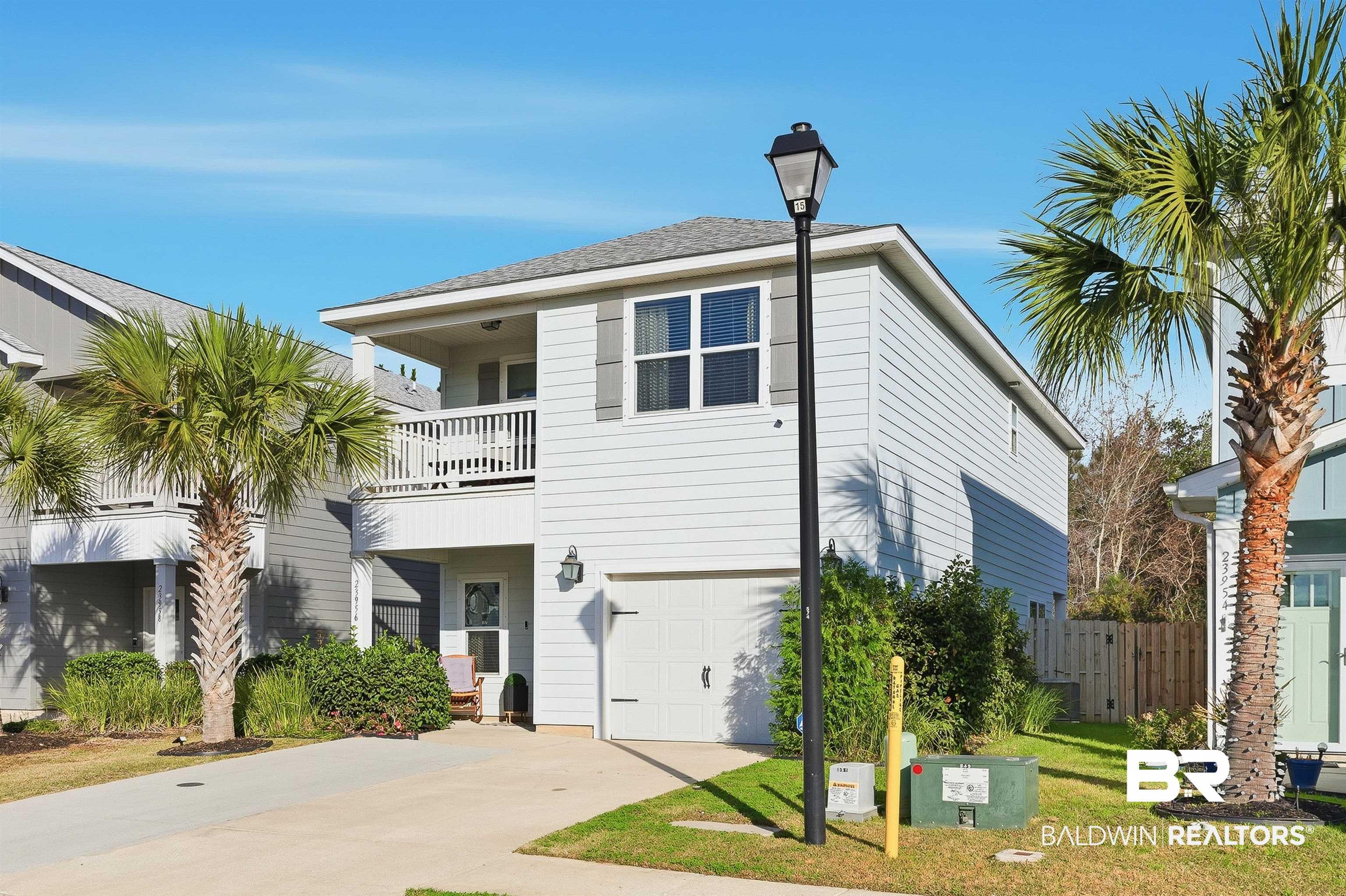 Image 4: View of front of home with a balcony, concrete driveway, and an attached garage