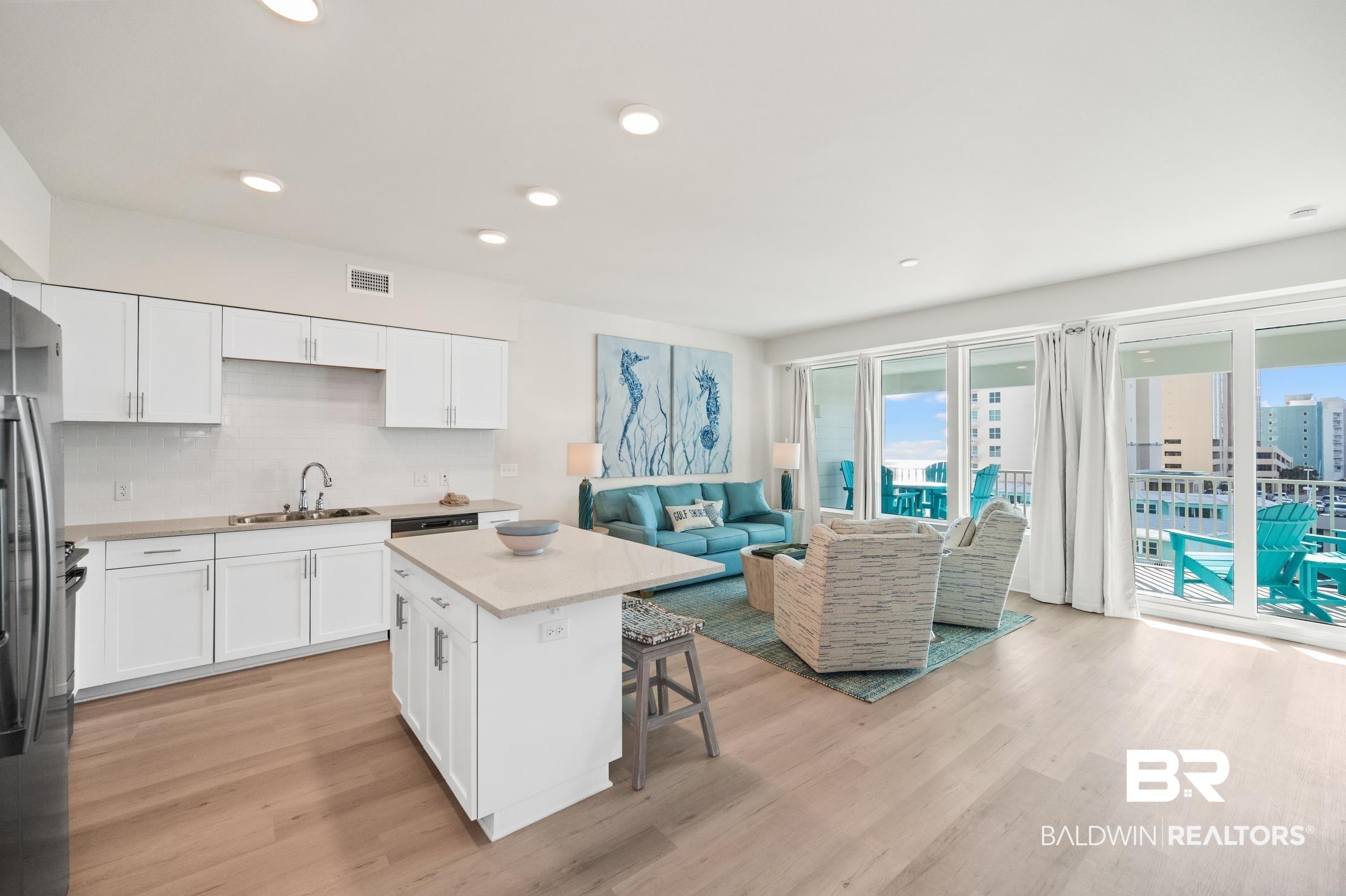 Image 2: Open-concept living area with wood-finish flooring
