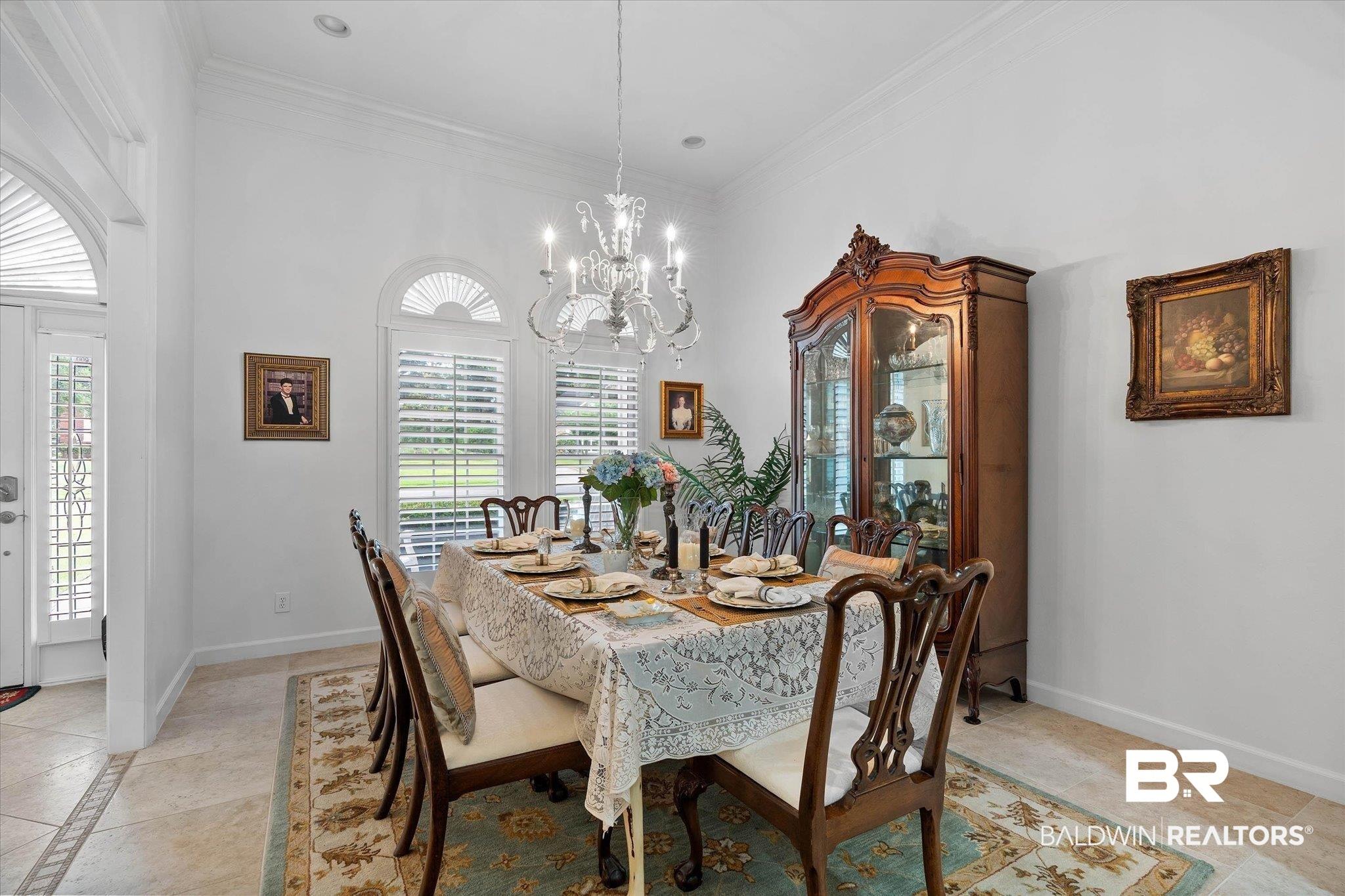 Image 3: Formal dining area featuring a crystal chandelier and tile flooring