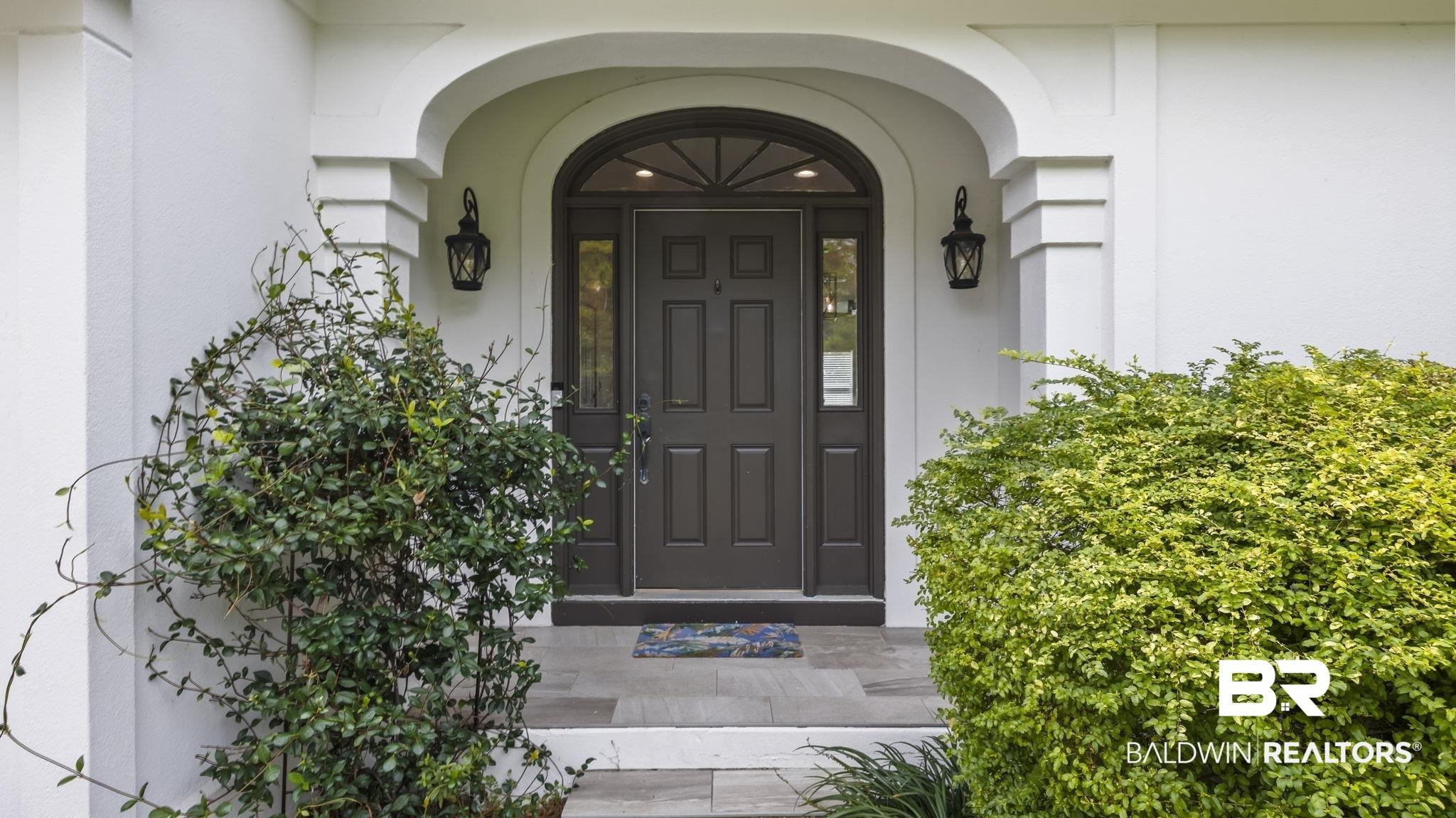 Image 3: View of exterior entry featuring stucco siding