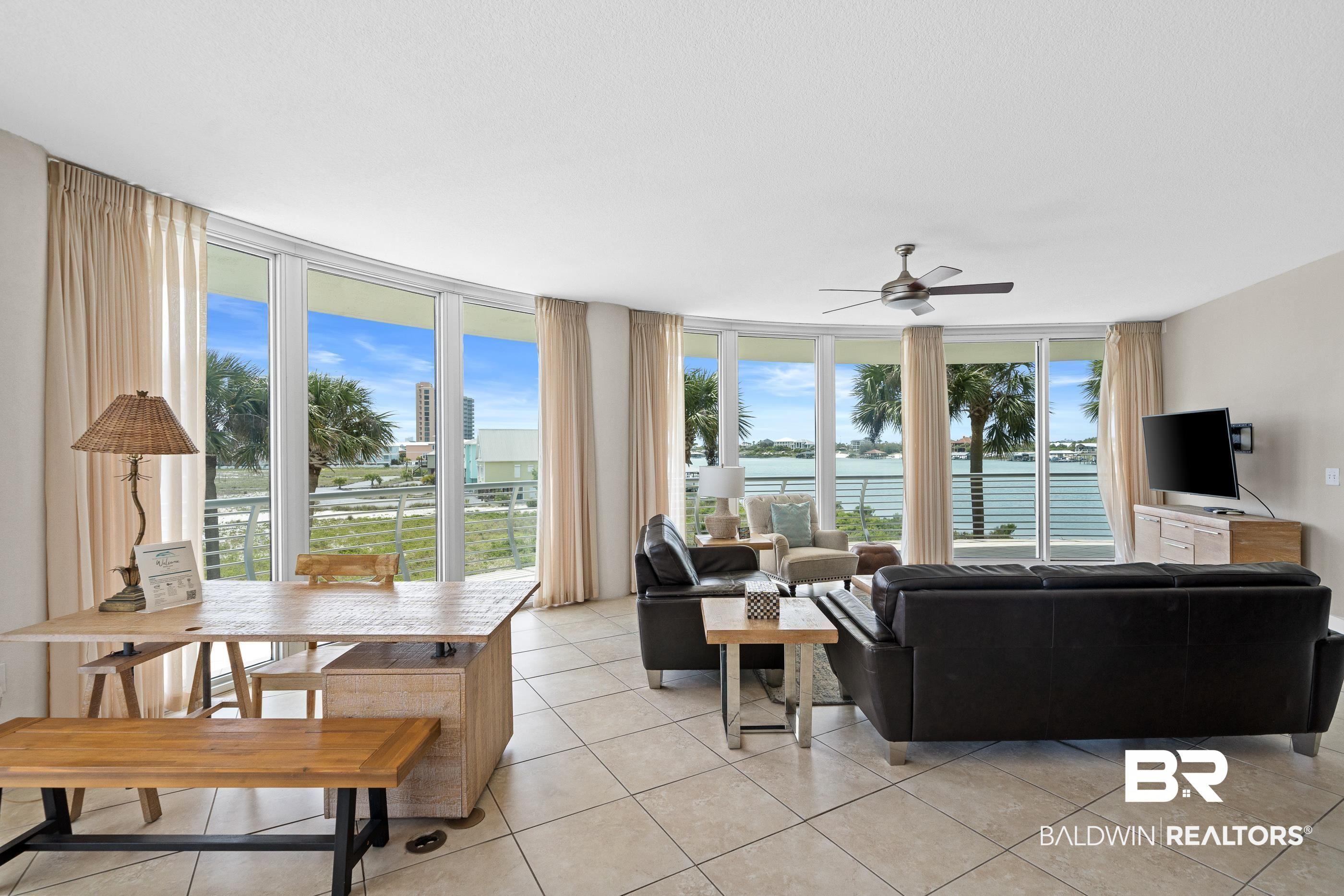 Image 4: Curved wall of floor-to-ceiling windows with water views and balcony access