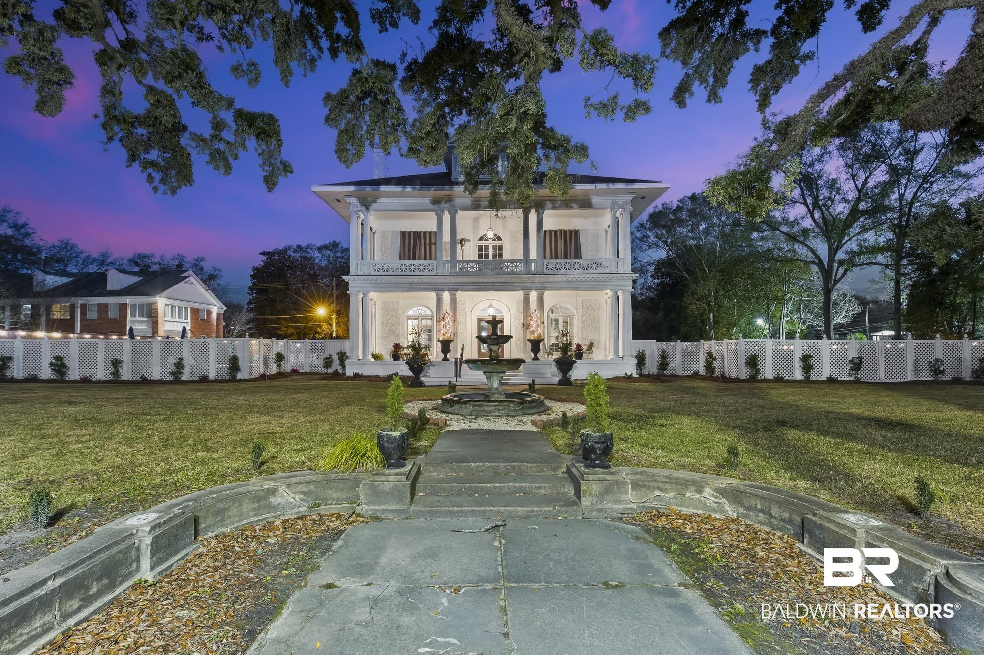 Image 2: View of front of house with a balcony and stucco siding