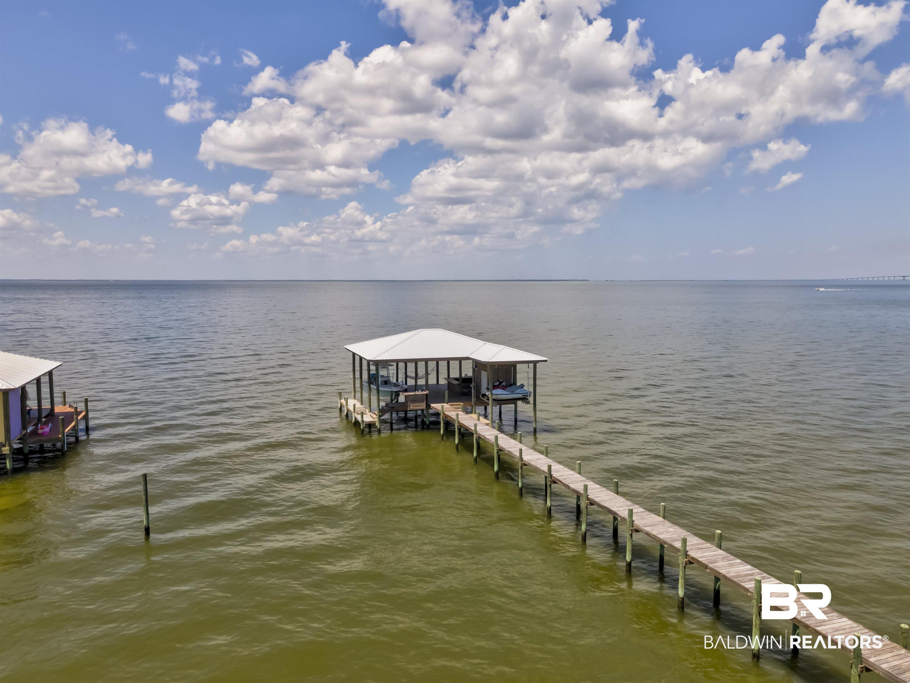 Image 2: Dock area with boat lift and a water view