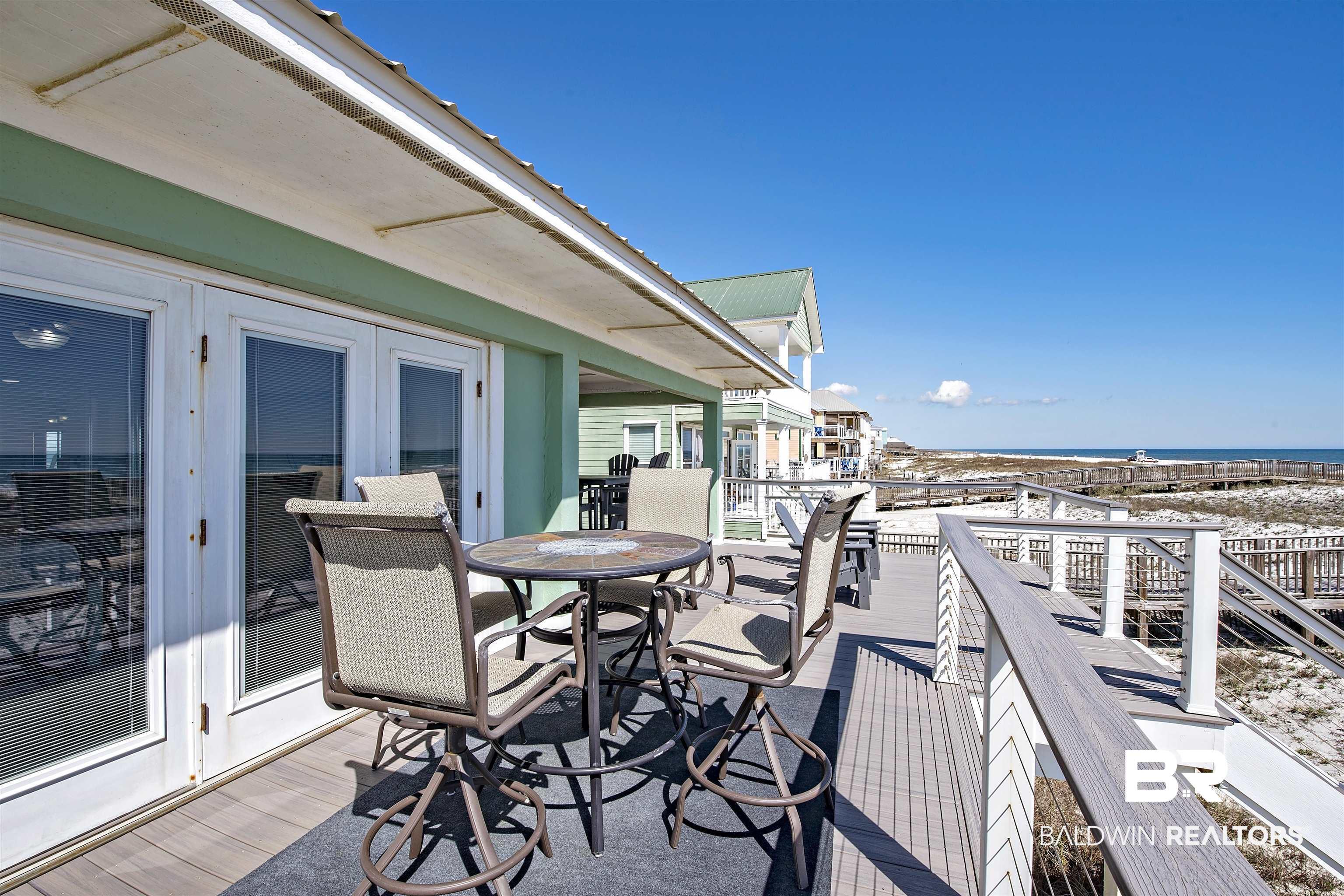 Image 3: Deck featuring outdoor dining area and a water view