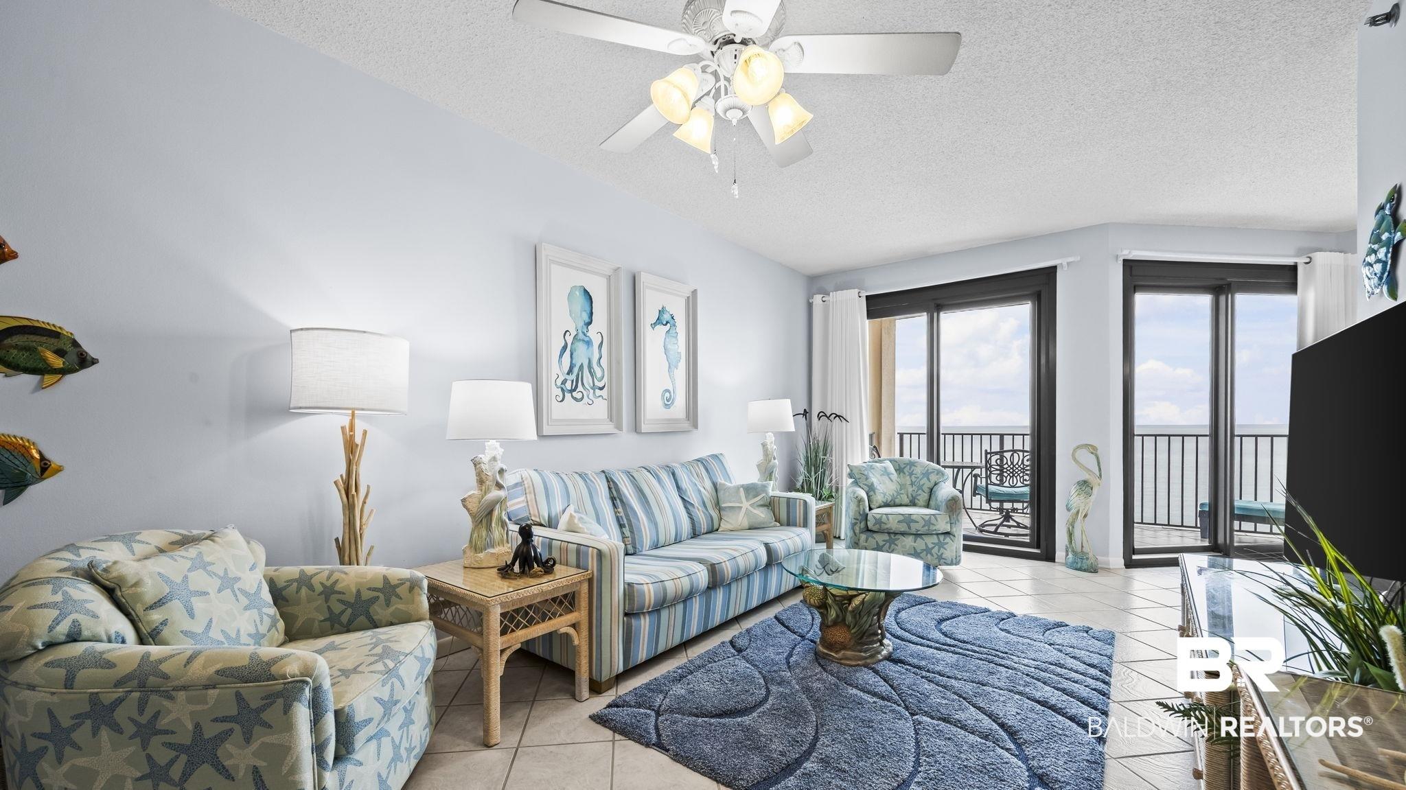 Image 3: Living room featuring a textured ceiling, light tile patterned floors, and a ceiling fan