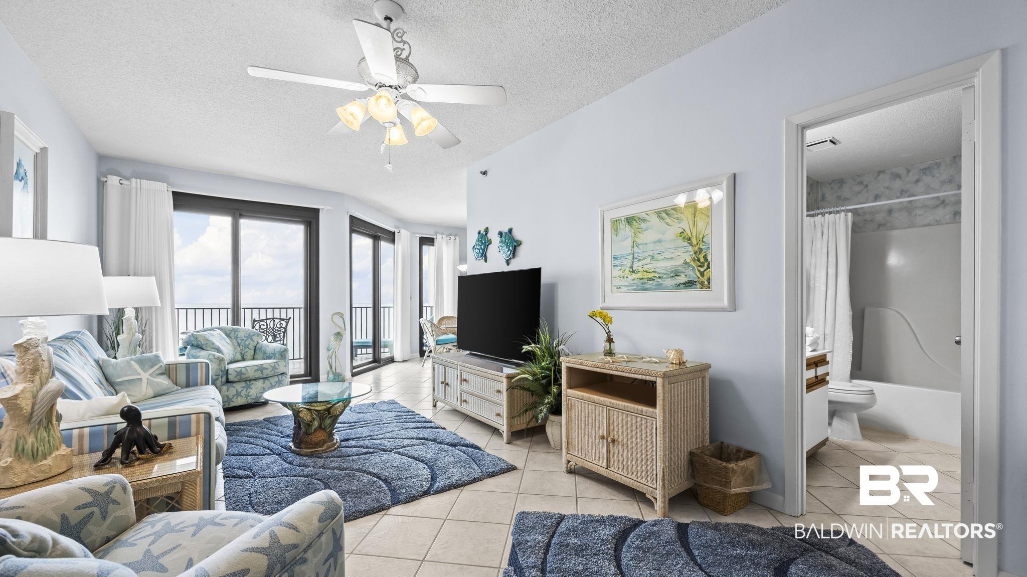 Image 4: Living area with a textured ceiling, a ceiling fan, and light tile patterned floors