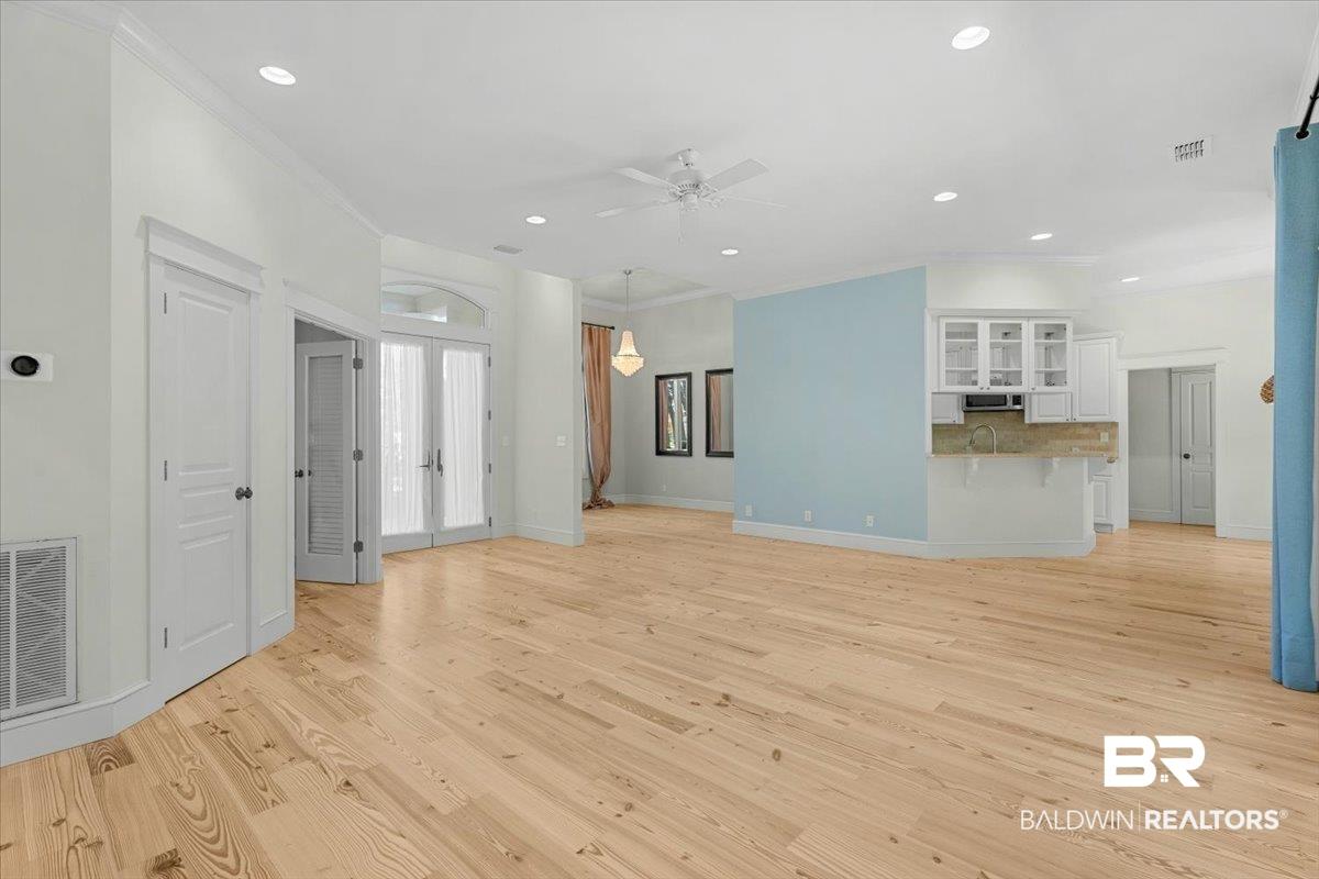 Image 4: Spacious interior featuring light wood-finish flooring, recessed lighting, and crown molding