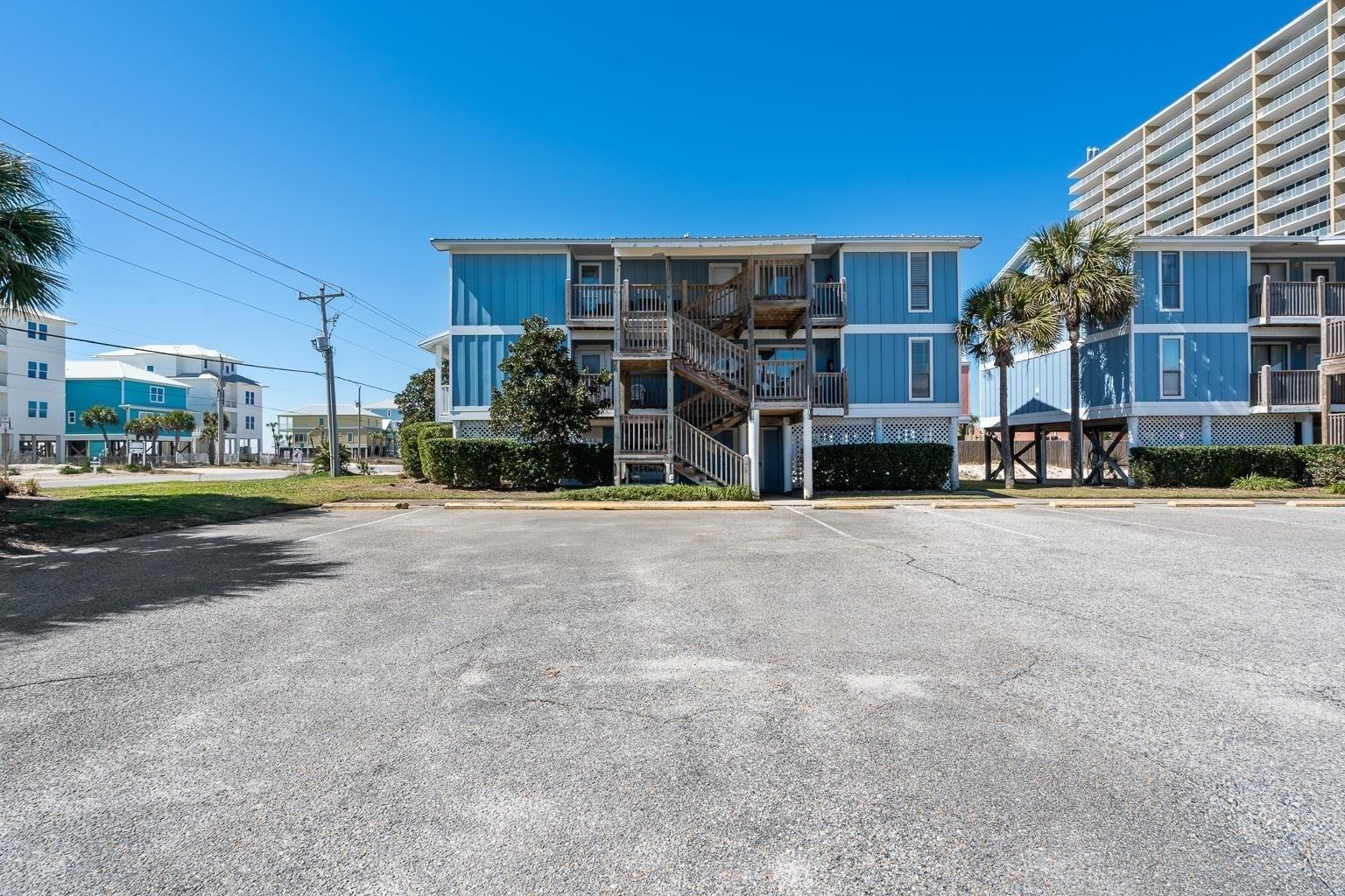 Image 3: View of building exterior with uncovered parking