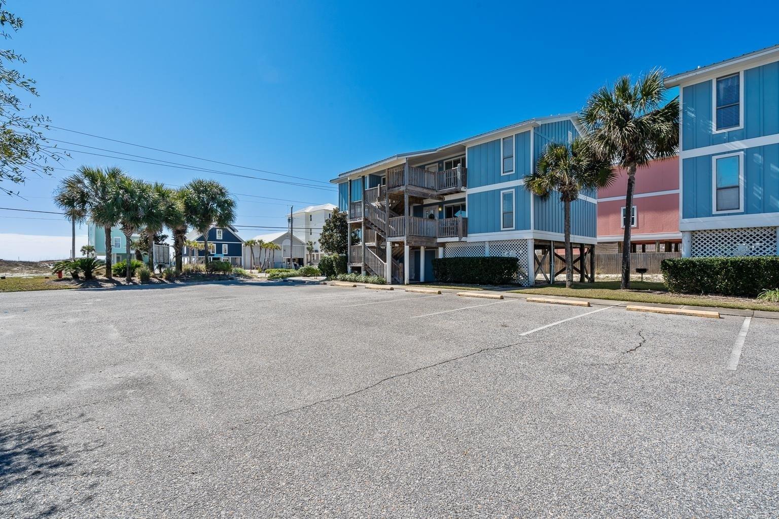 Image 4: View of building exterior featuring uncovered parking