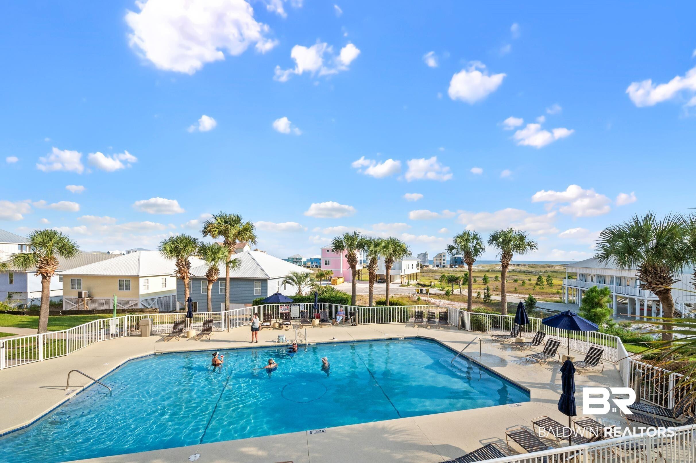 Image 3: Community pool featuring a patio, fence, and a residential view