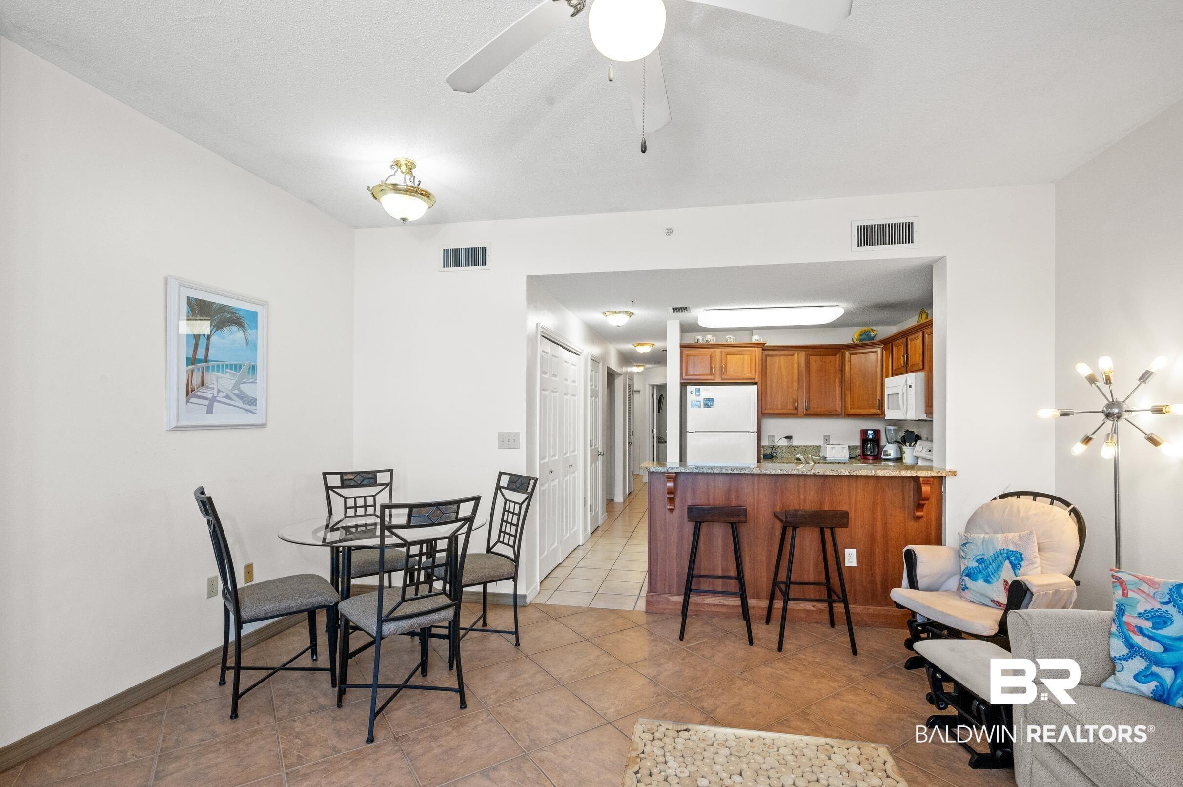 Image 4: Dining area featuring a ceiling fan, visible vents, baseboards, and light tile patterned flooring