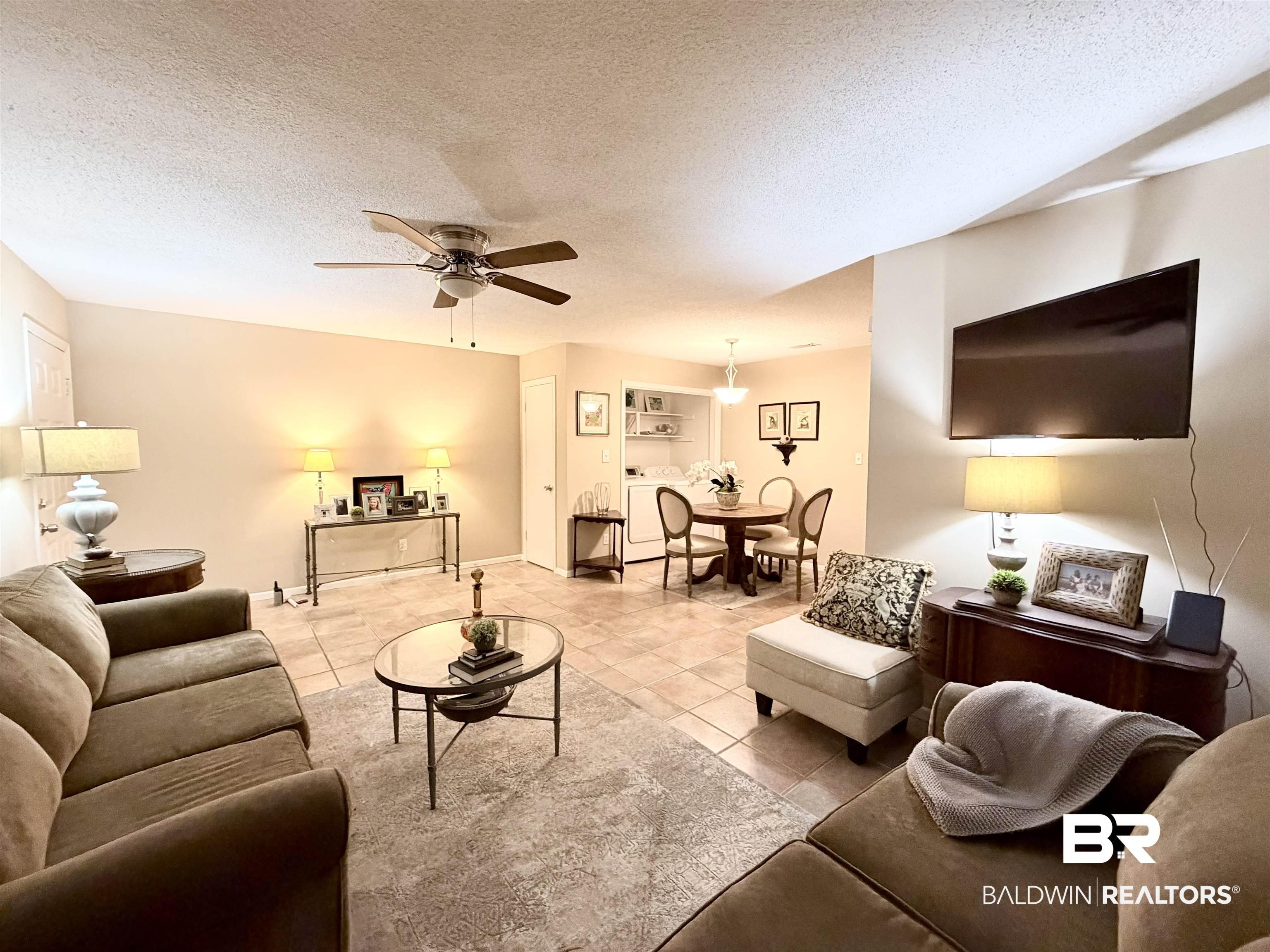 Image 3: Tiled living area with a textured ceiling and ceiling fan