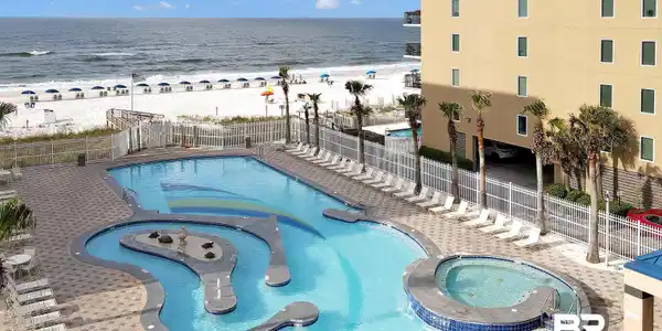Image 4: Expansive outdoor pool deck featuring a large swimming pool with an integrated lazy river and a separate hot tub