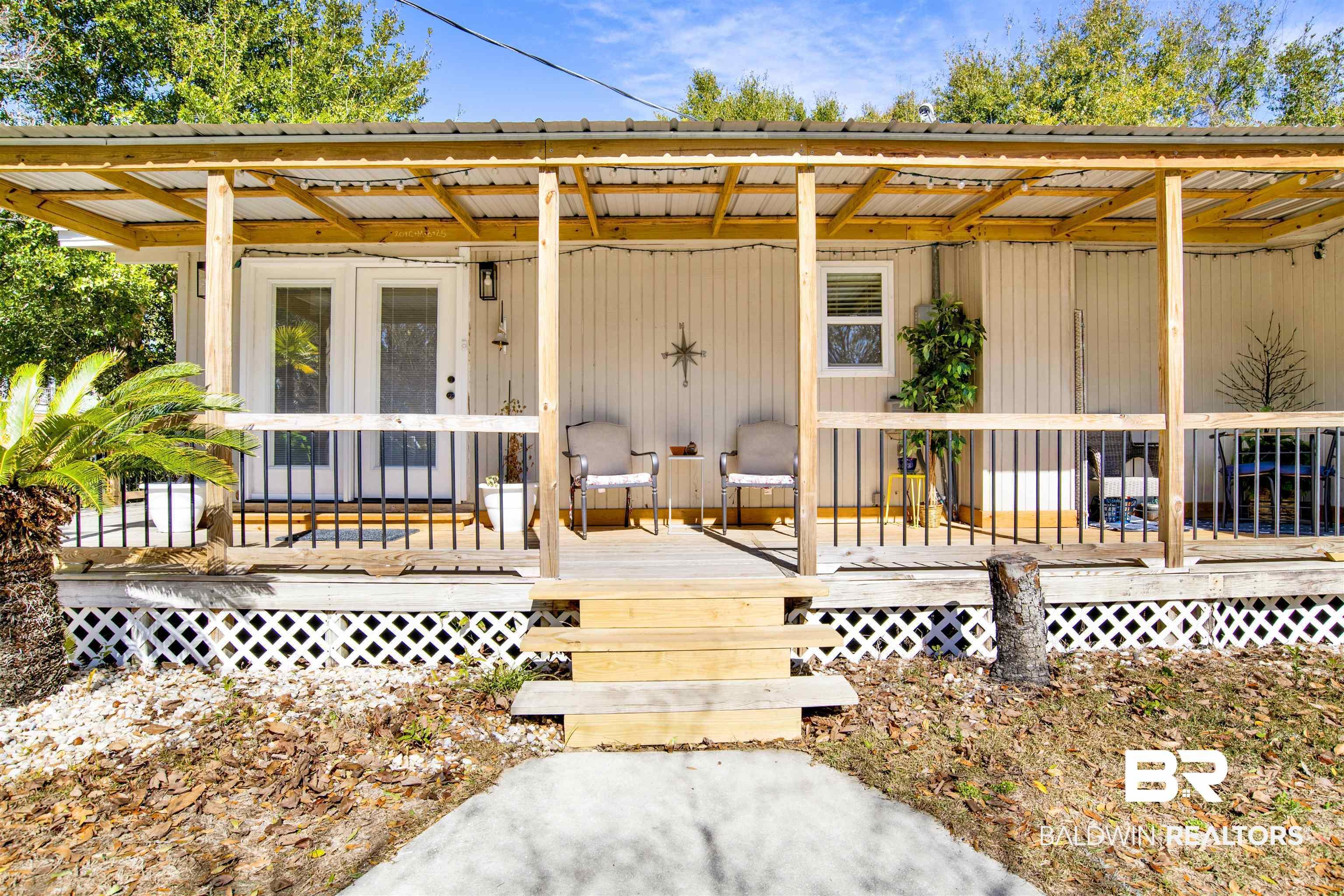 Image 1: View of exterior entry featuring a metal roof and a wooden deck