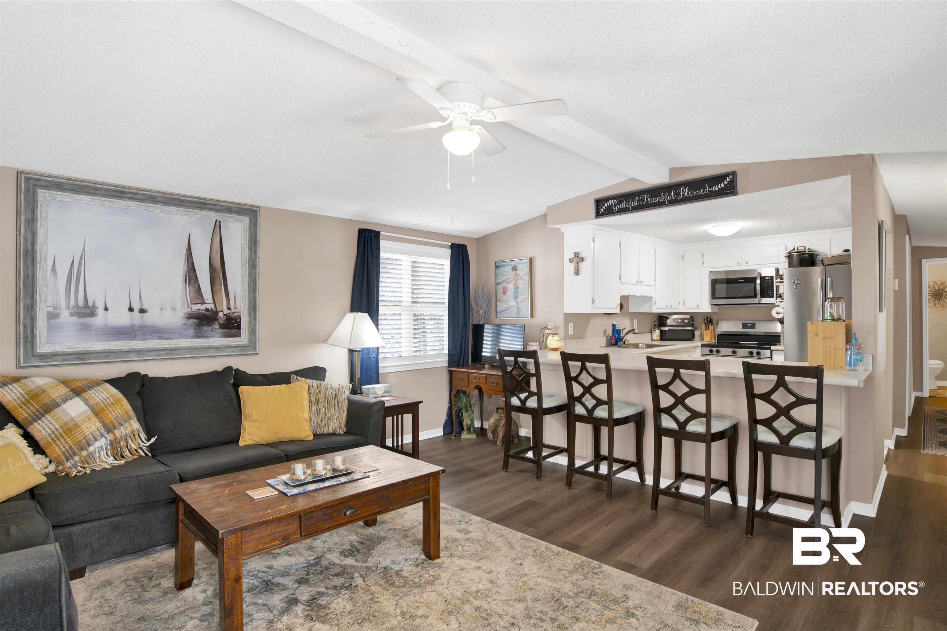 Image 2: Living room with dark wood-style flooring and a ceiling fan