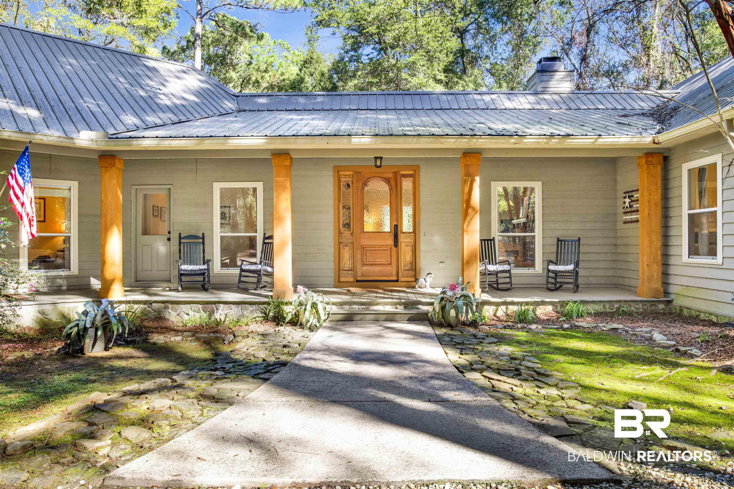 Image 3: Doorway to property with covered porch, a metal roof, and a chimney
