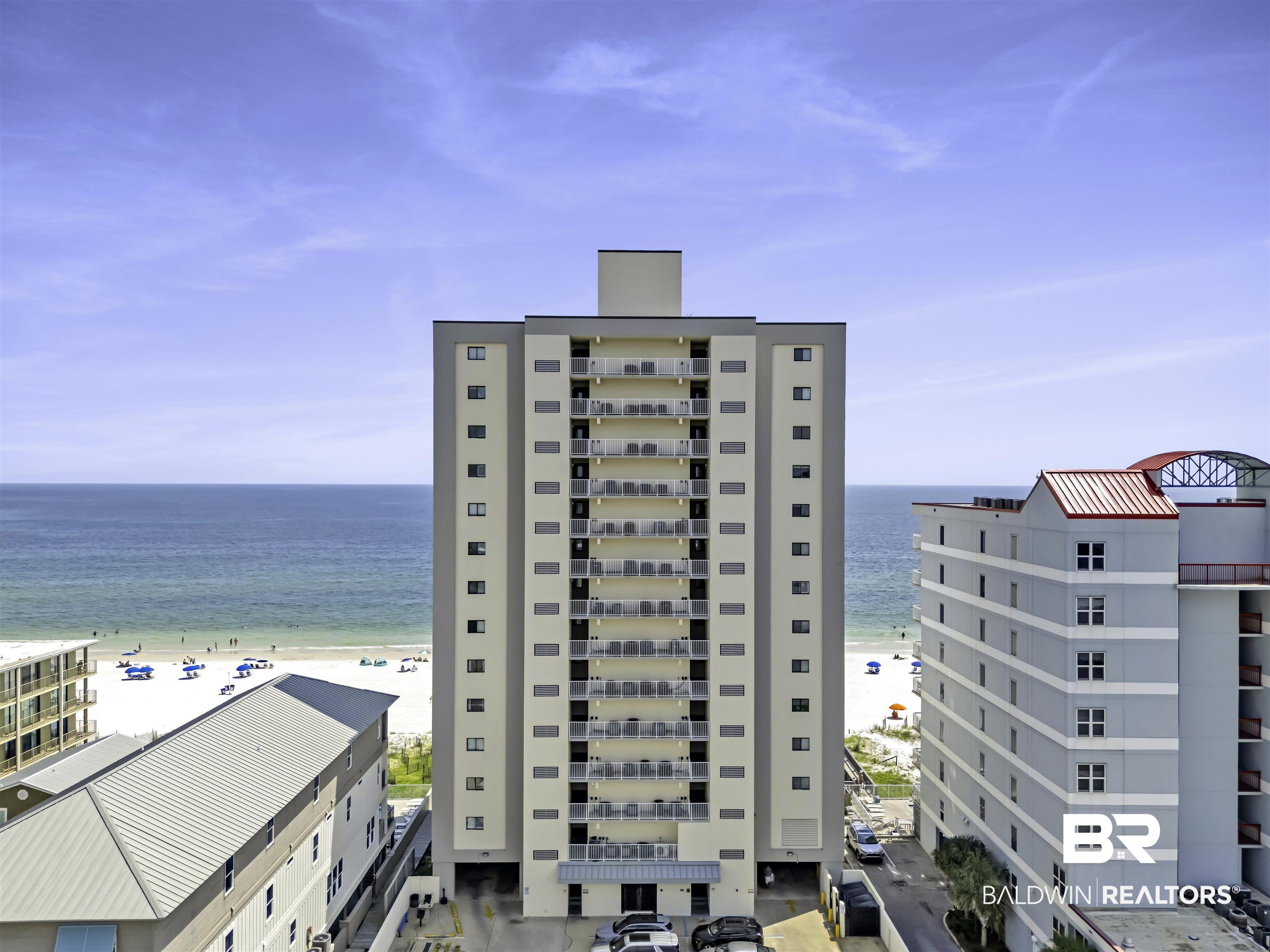 Image 1: View of apartment building / complex featuring view of water and beach