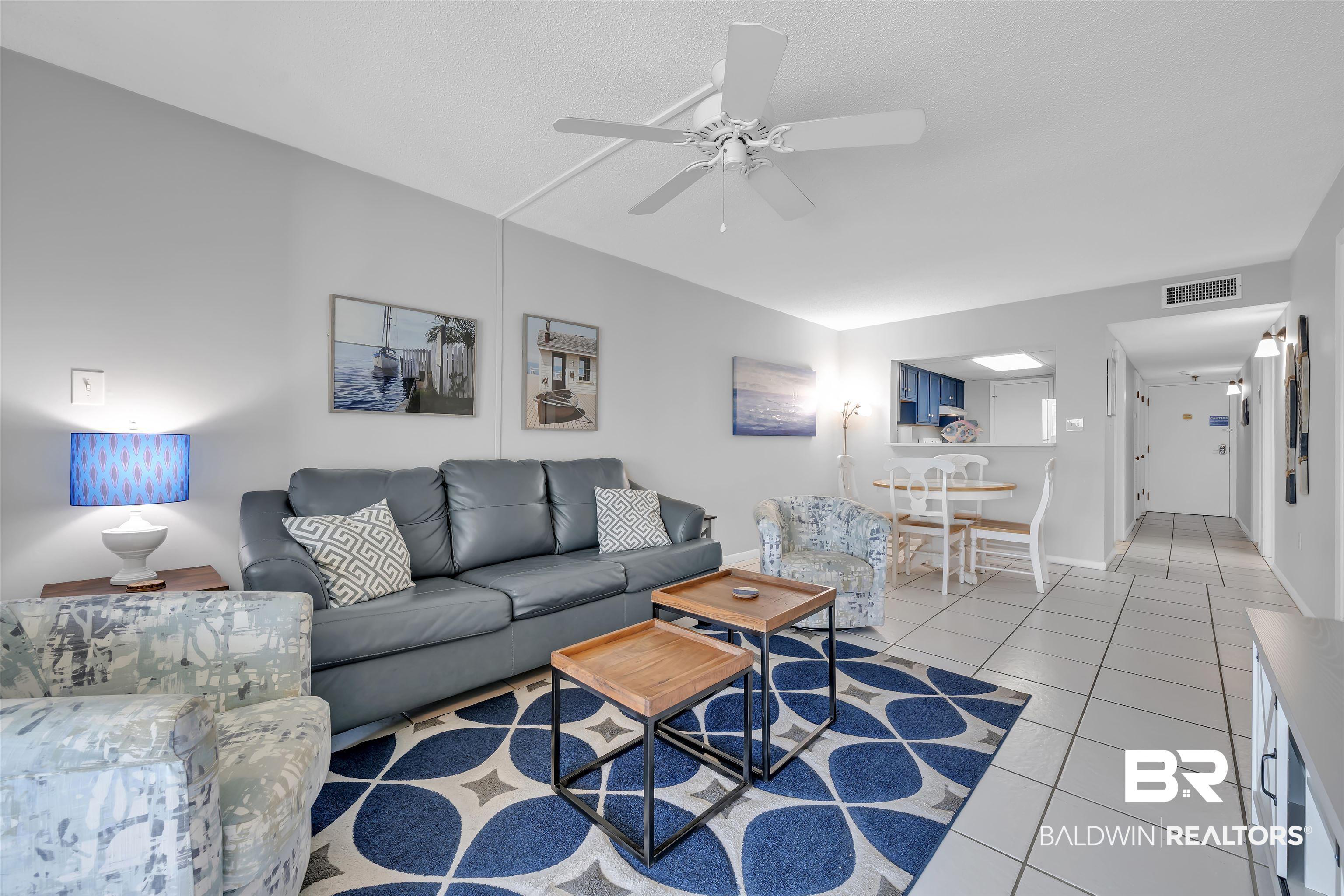 Image 4: Living room with light tile patterned floors and ceiling fan