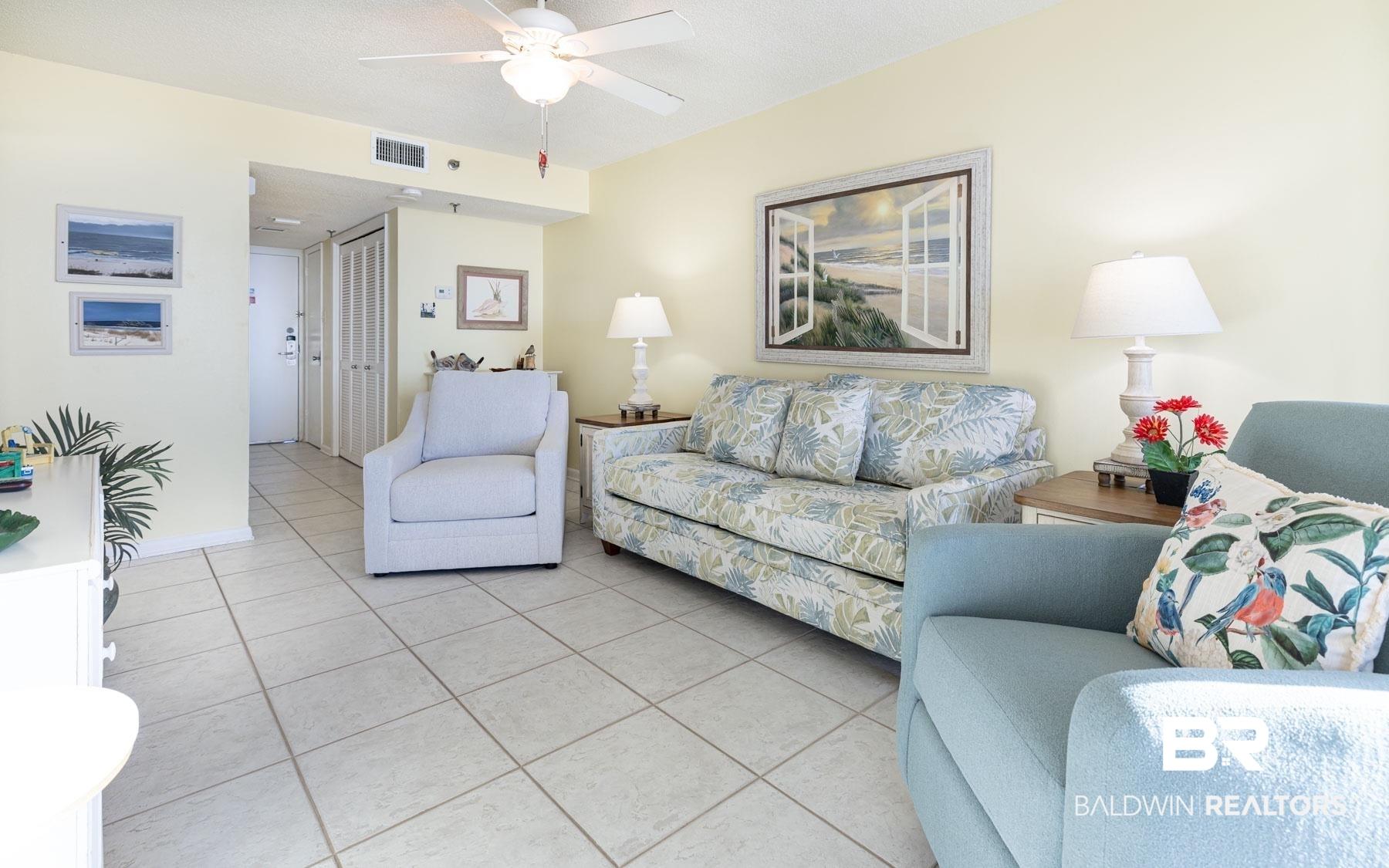 Image 3: Living room featuring light tile patterned floors and a ceiling fan