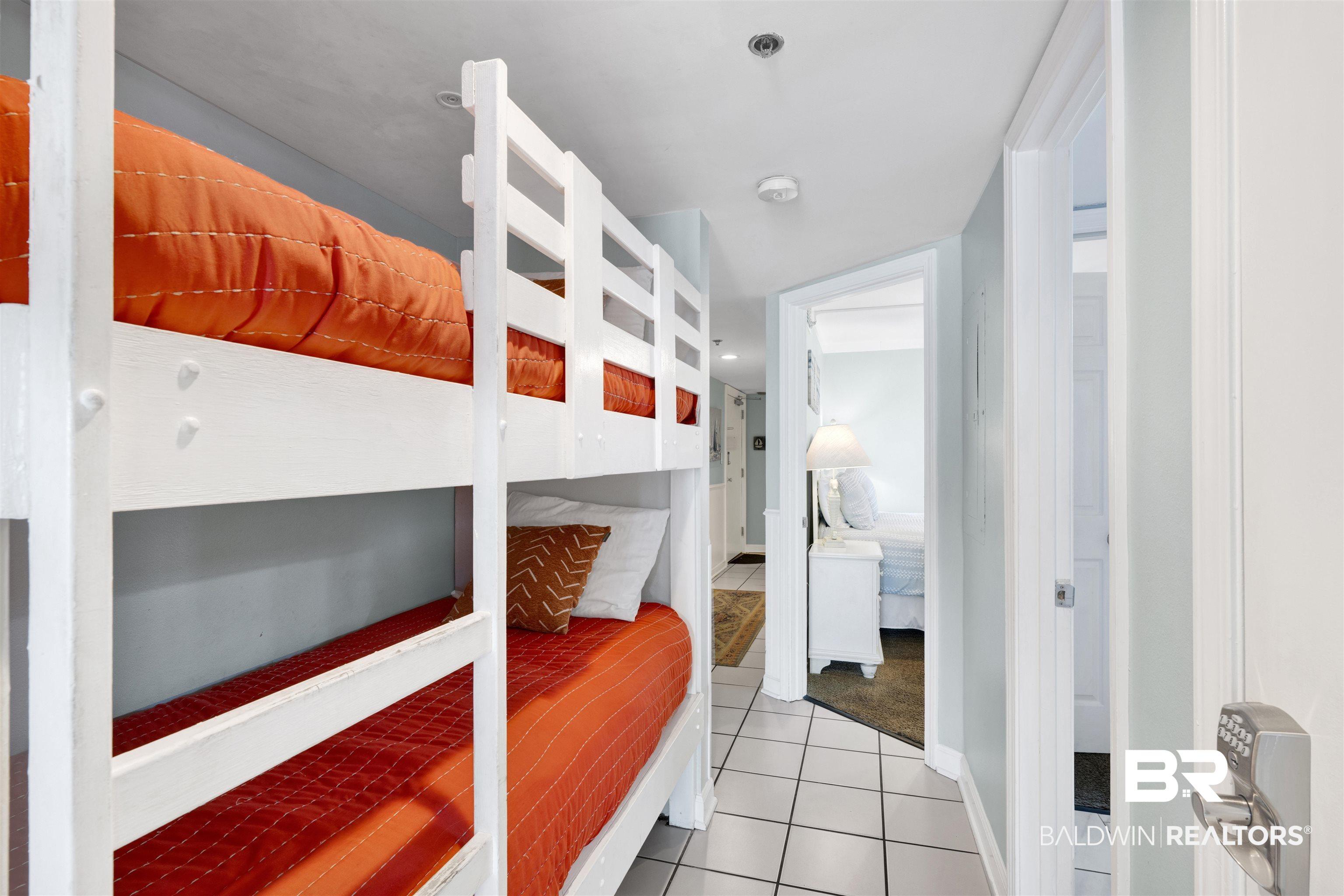 Image 4: Bedroom featuring light tile patterned flooring and baseboards