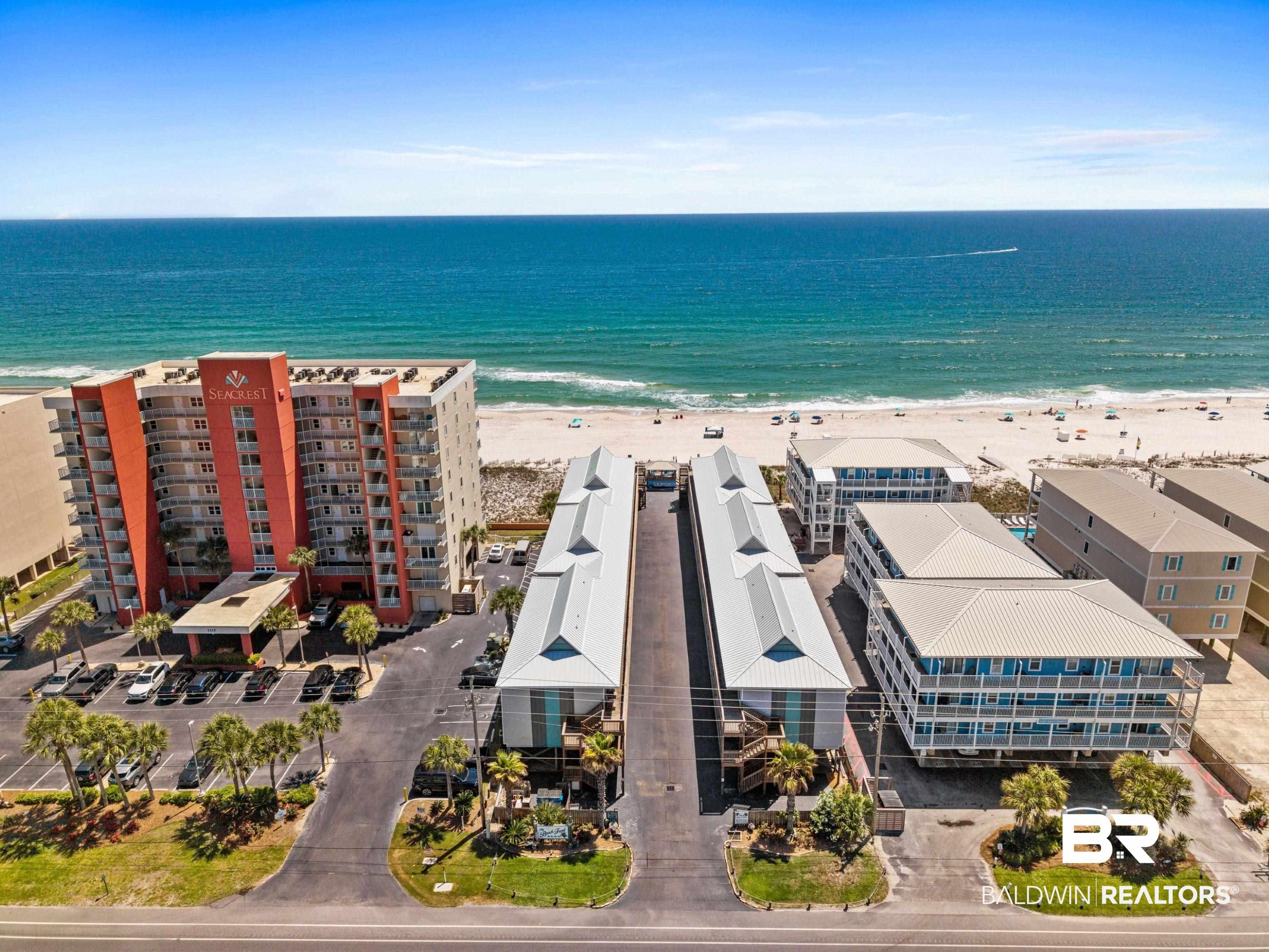 Image 3: Aerial view of waterfront with a beach and apartment complex / building