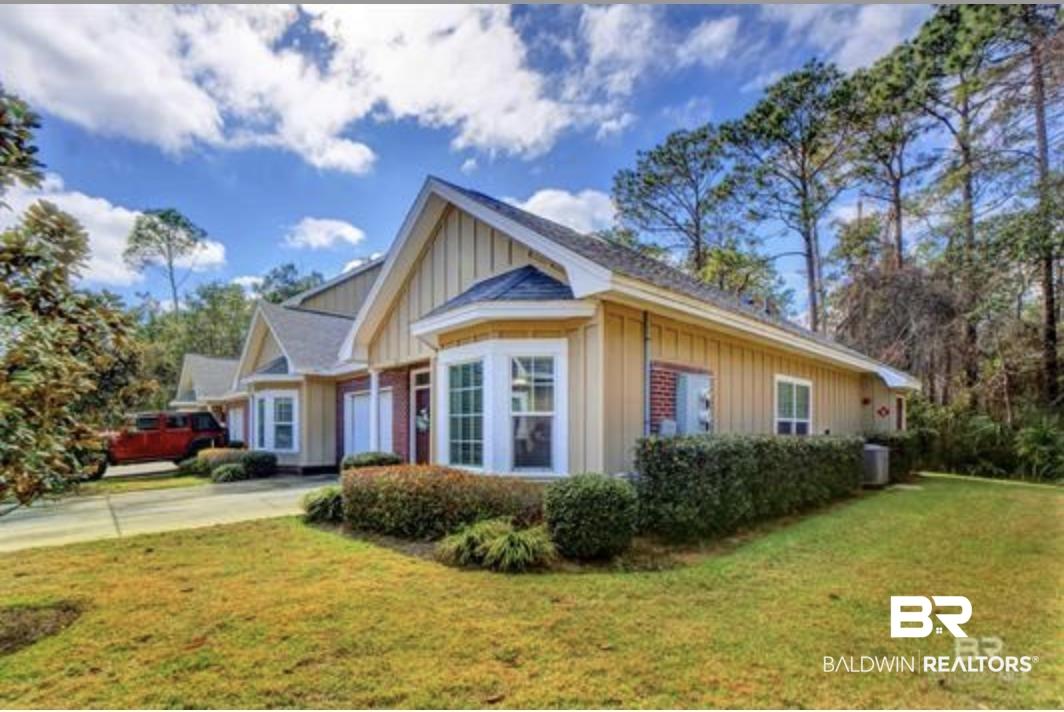 Image 2: Exterior featuring bay windows, vertical board and batten siding, brick accents, and a shingled roof
